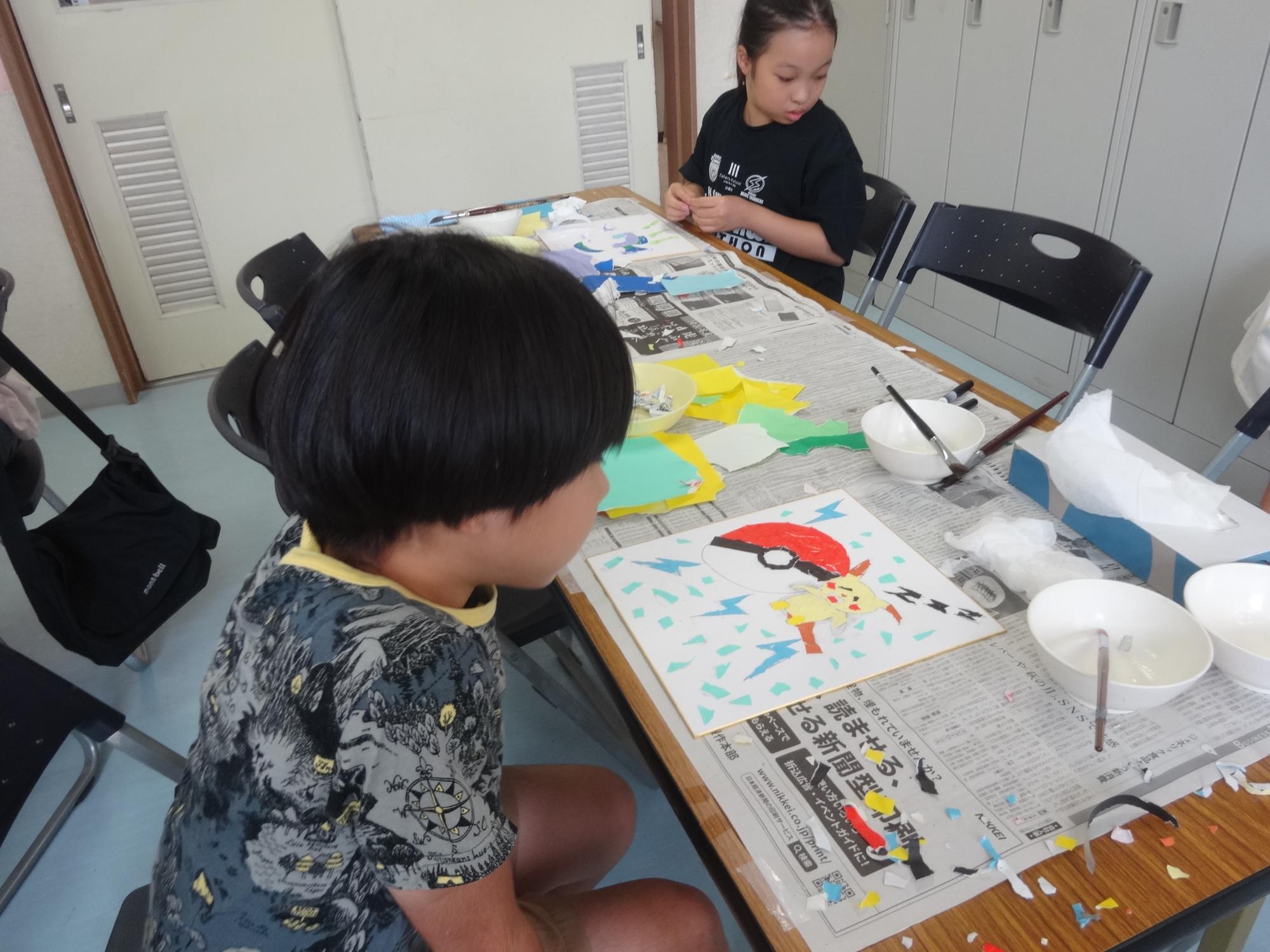 もう少しで完成しそうな作品を見直している小学生