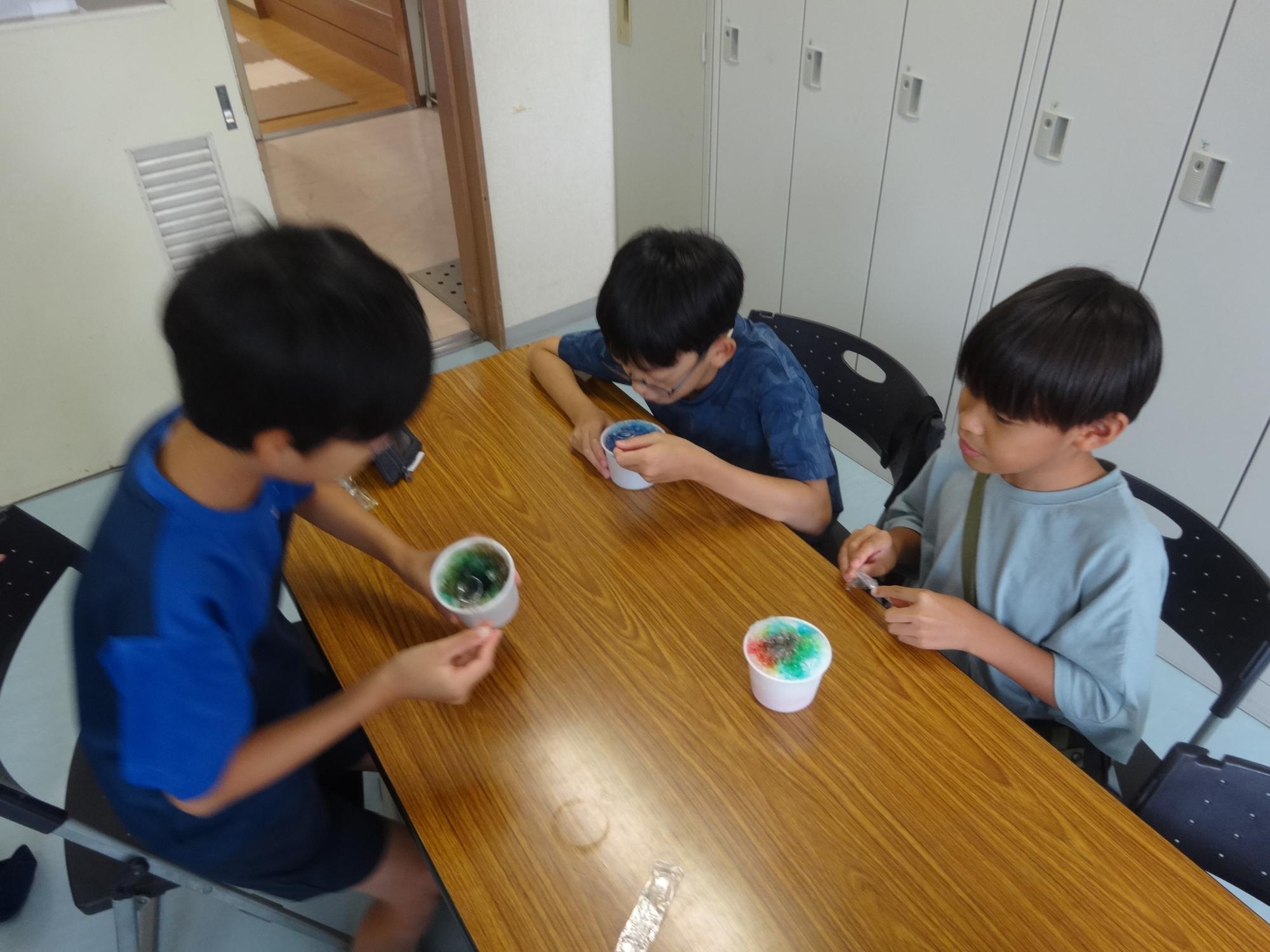カラフルなかき氷を食べる小学生たちの写真