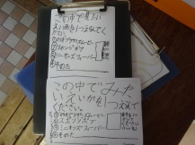 子供たちが作った手書きのアンケートの回答用紙を撮影している写真