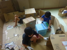 段ボールで仕切りが作られており中でチームになり作業する3人の男の子の写真