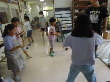 玄関前のスペースでけん玉をする子どもたちの写真