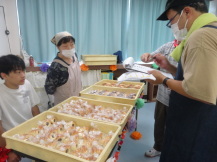 沢山のパンが入った番重が4箱テーブルに並べて置かれている写真