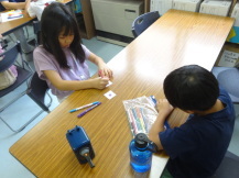 テーブルに対面で座った子ども2名がカラーペンで絵を描いている写真