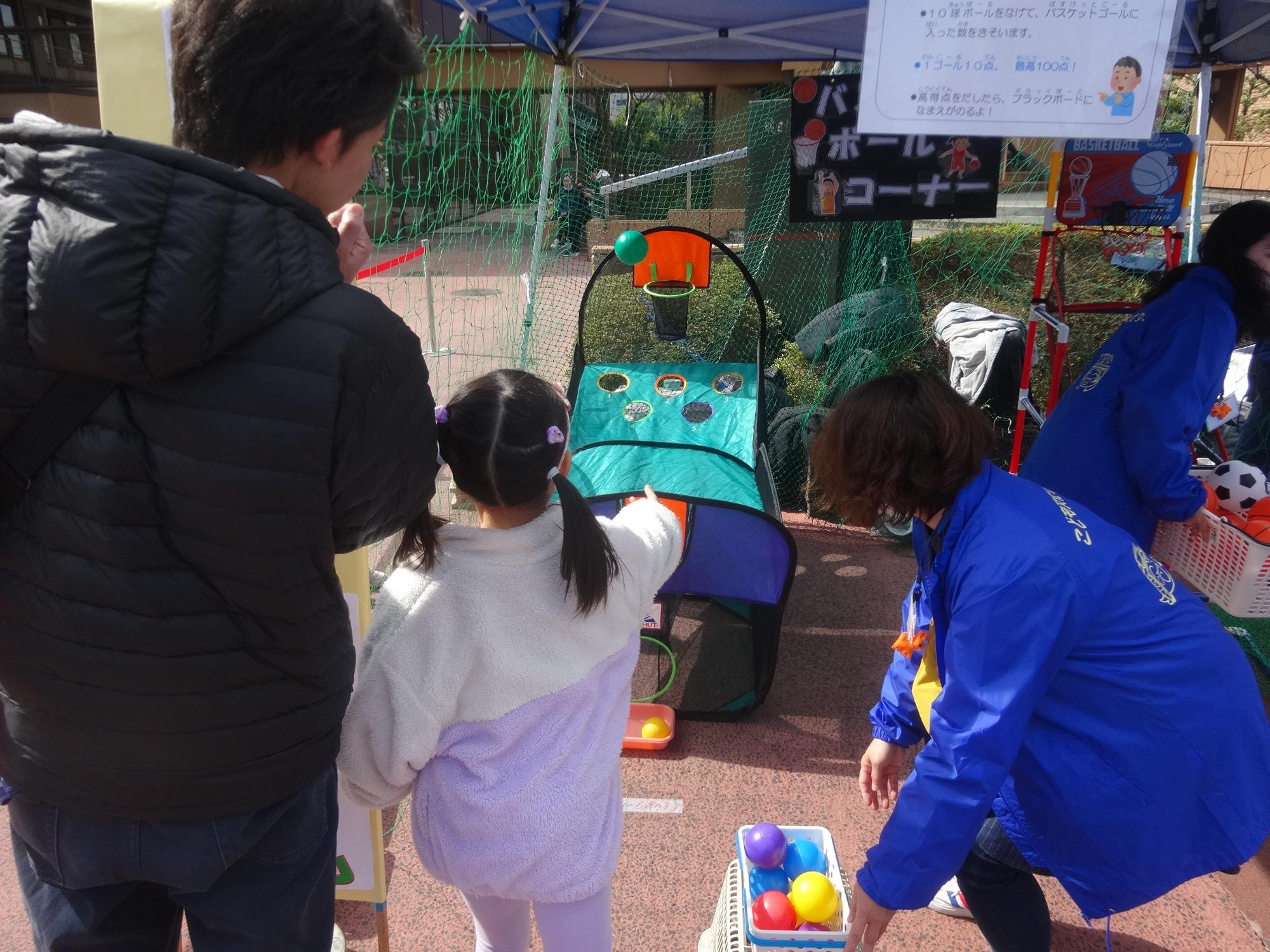 バスケットボールゲームに挑戦している幼児の写真