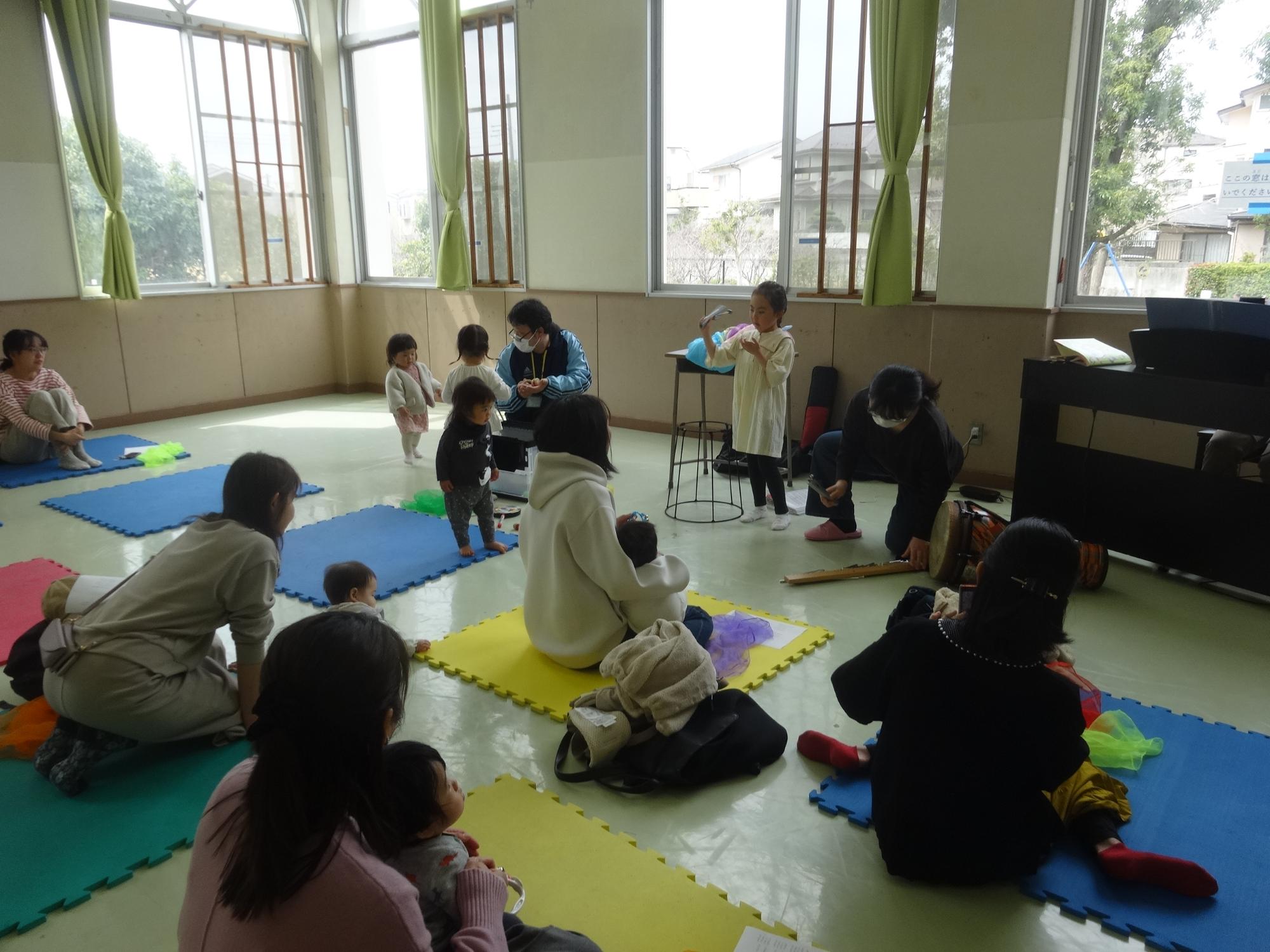 先生が用意した打楽器を興味津々で触る幼児さん達の写真