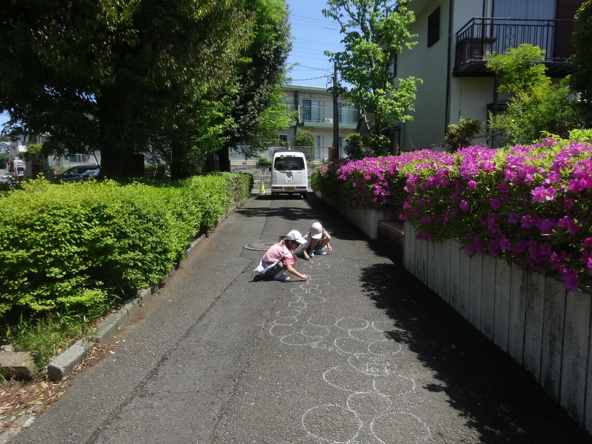 チョークを使って地面に絵を描く子どもたち