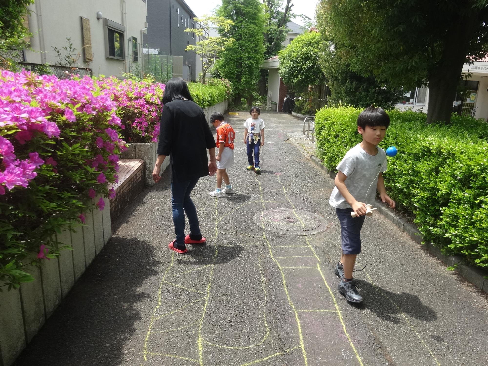 地面に大きく描いたあみだくじで遊ぶ人たち
