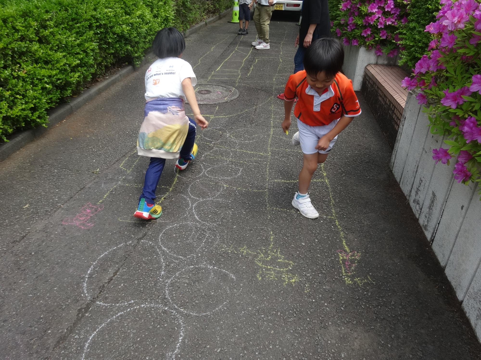 地面に大きく描いたあみだくじで遊ぶ人たち