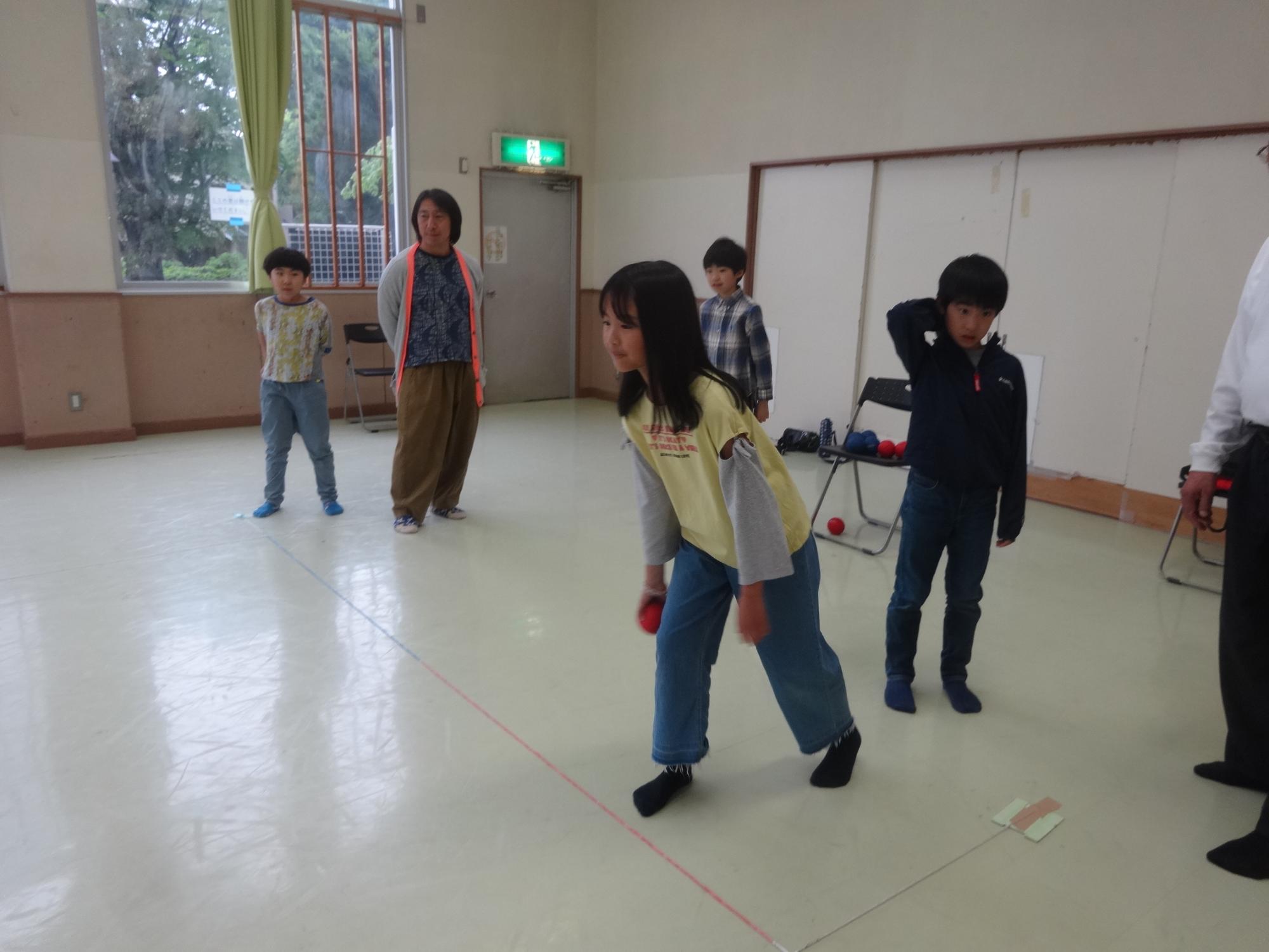赤いボールを投げる小学生