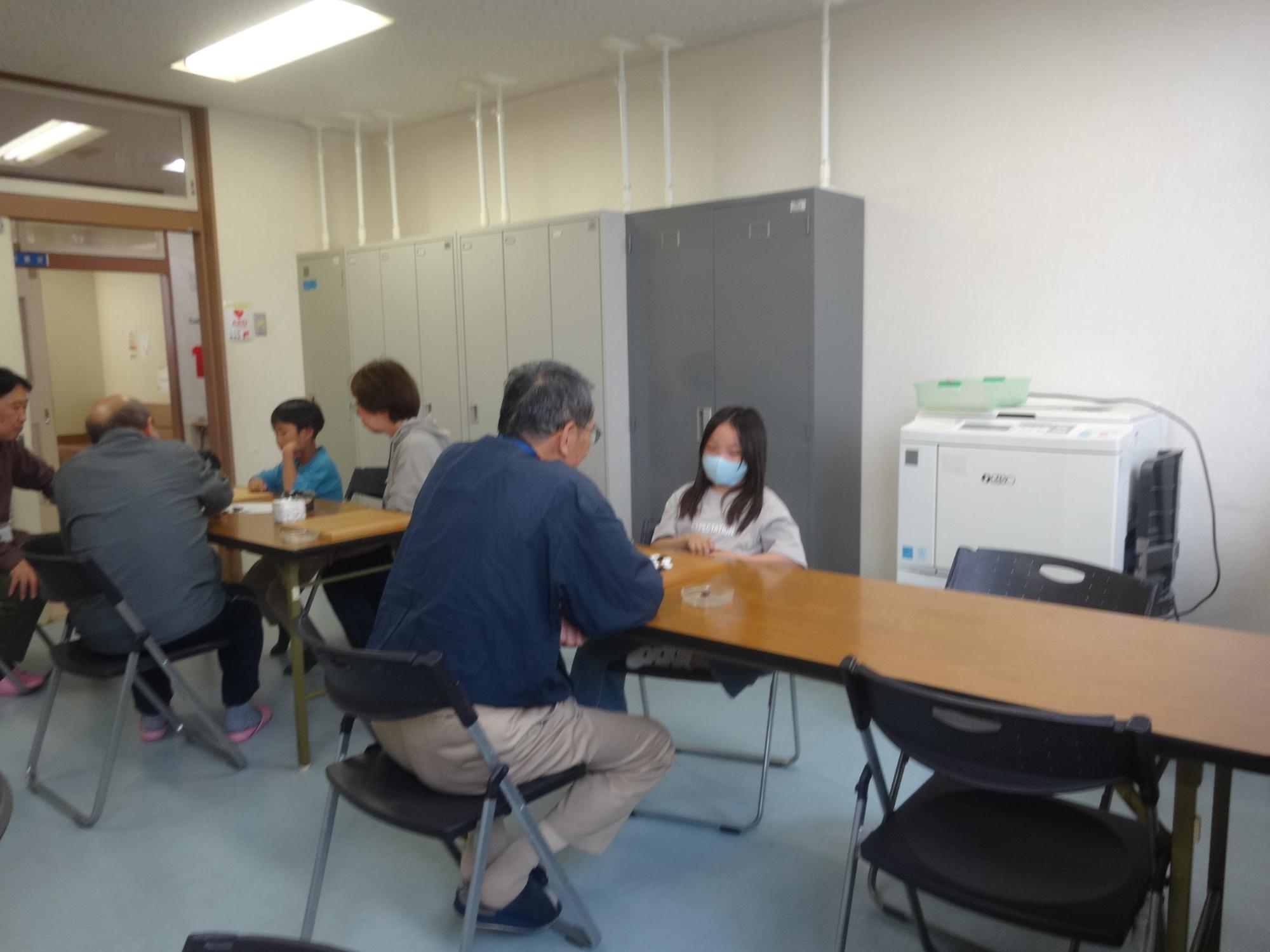 先生から囲碁を教えてもらう小学生