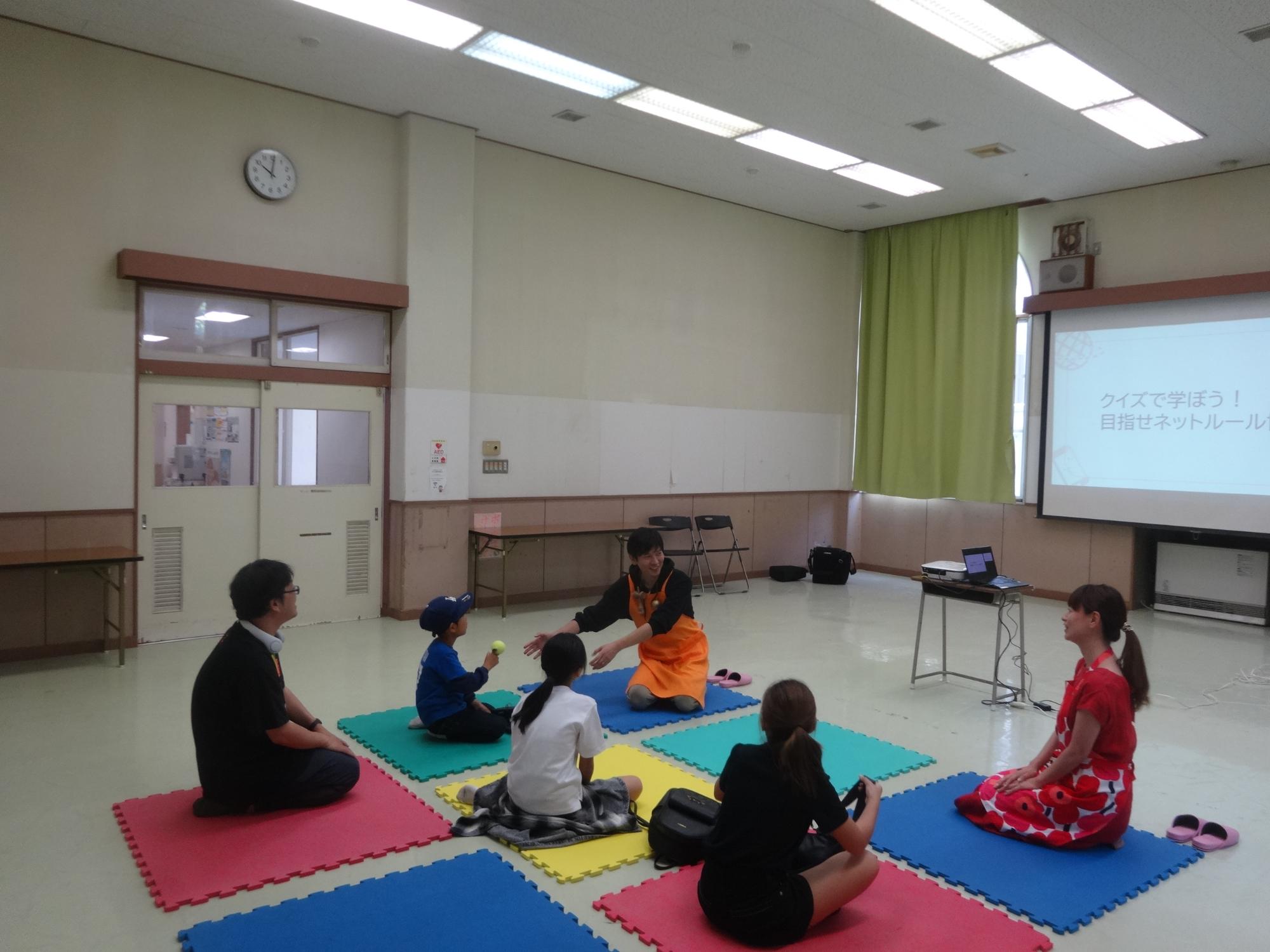 クイズを交えながらネットルールについて学ぶ3人の小学生たちの写真