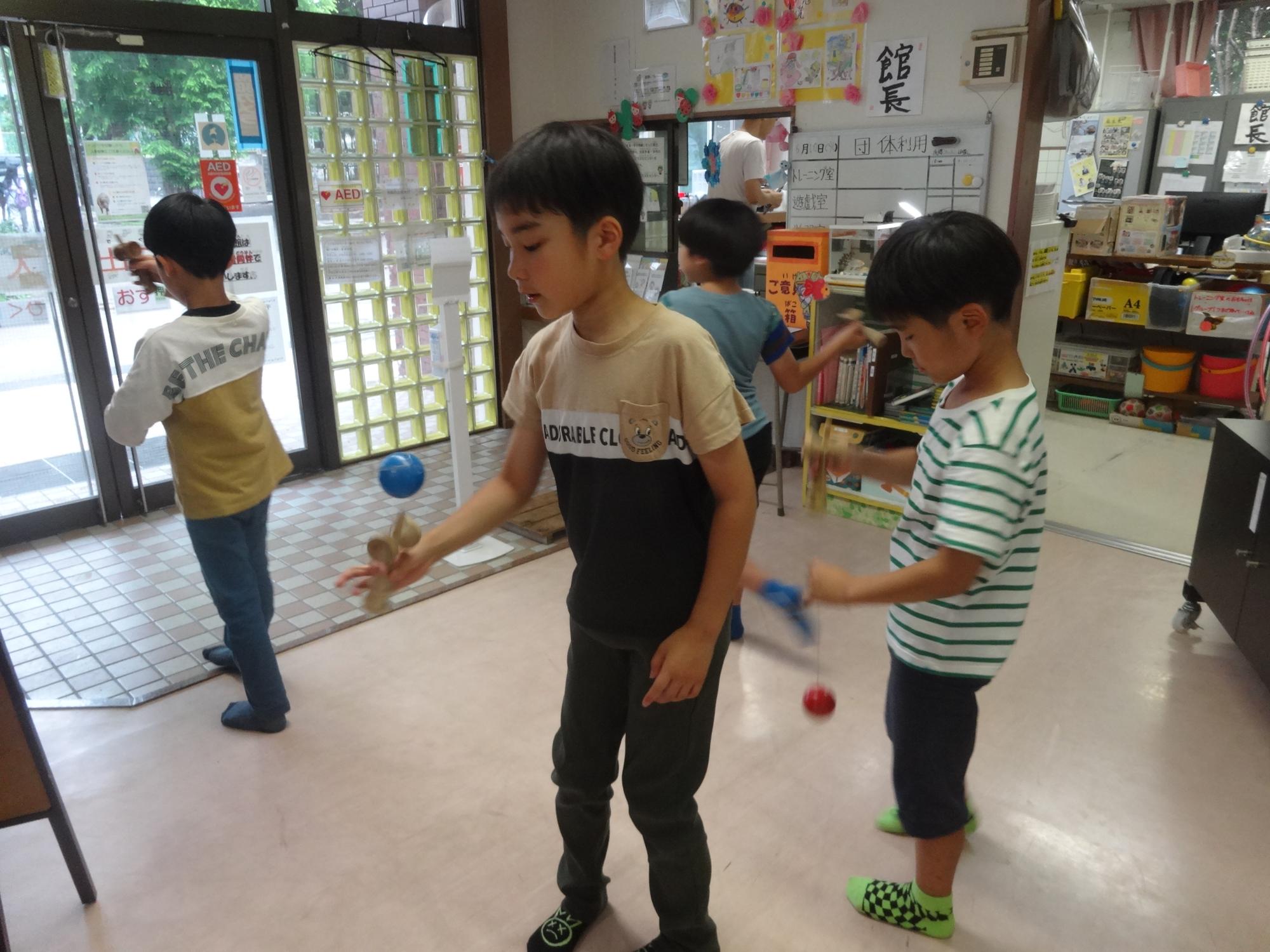 けん玉検定前に練習を行う小学生の写真