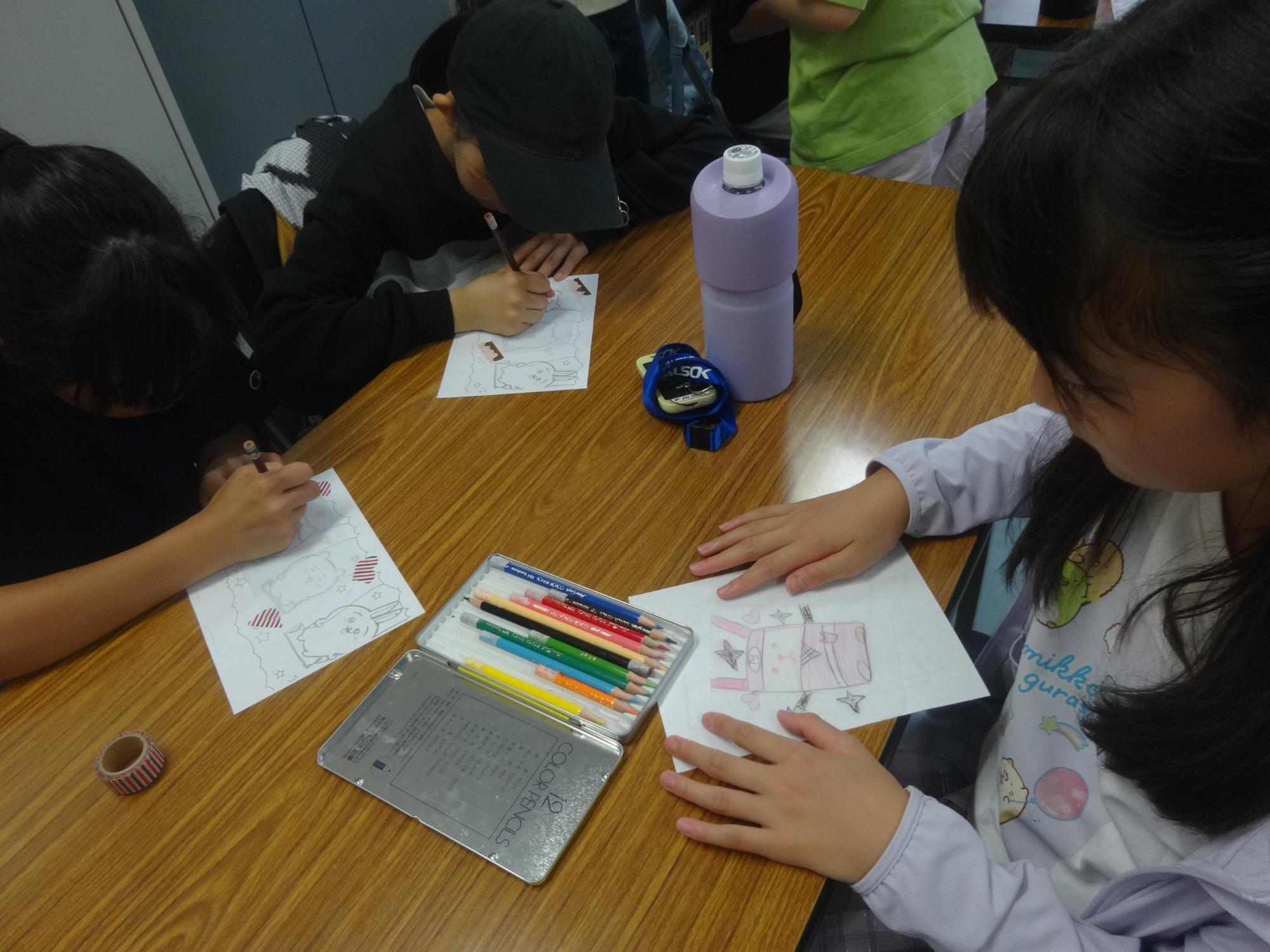 プラバンにかわいいイラストを描く小学生の写真