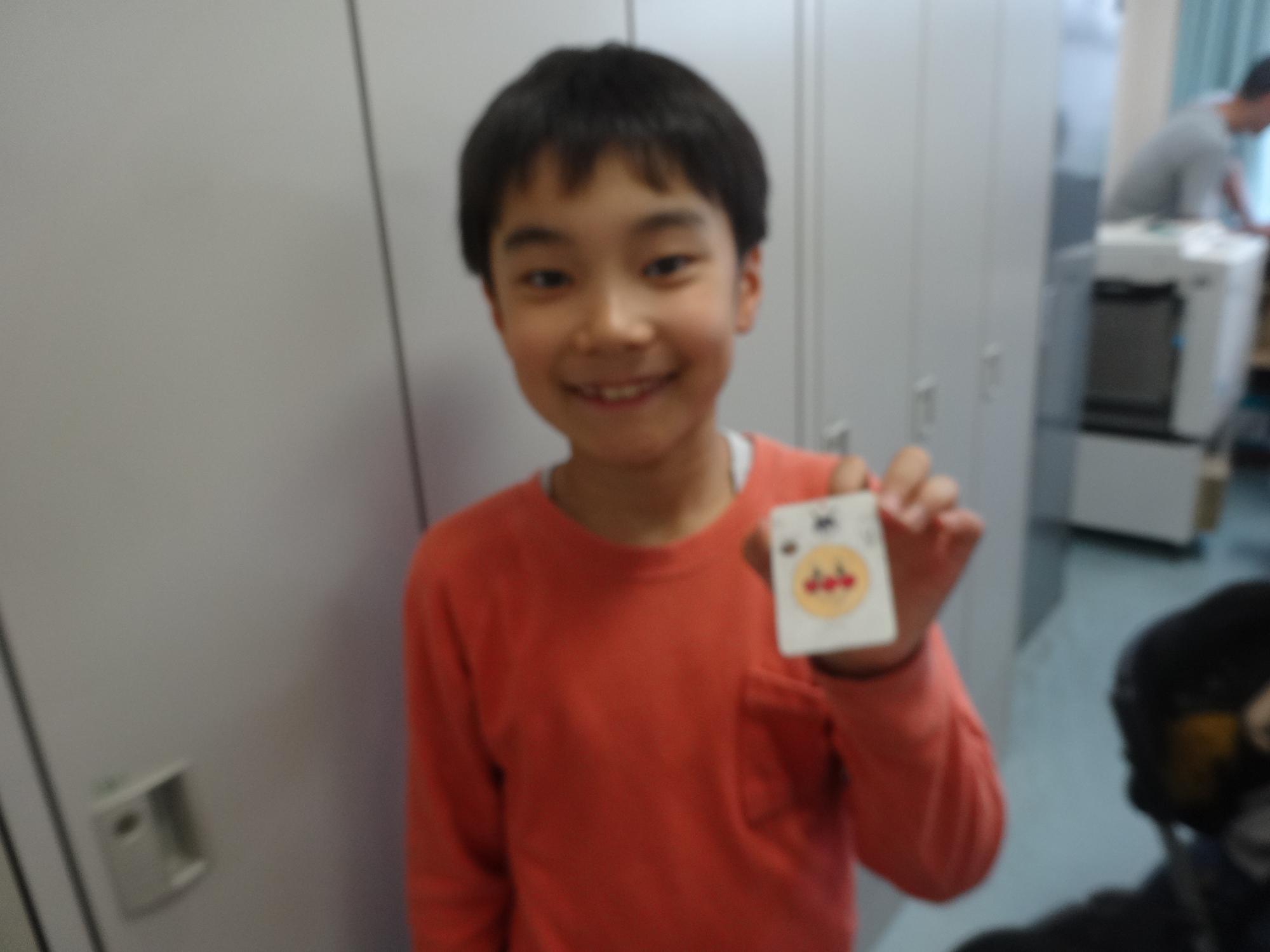 アンパンマンのプラバンキーホルダーを作り、笑顔の小学生の写真
