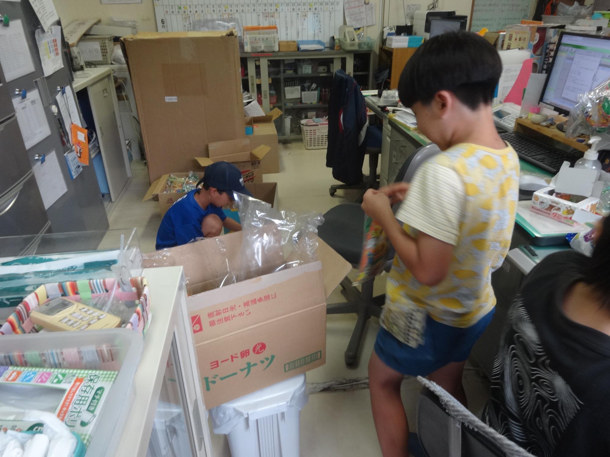 ワンダーハッピーシネマで配るお菓子を袋に詰める作業をする小学生