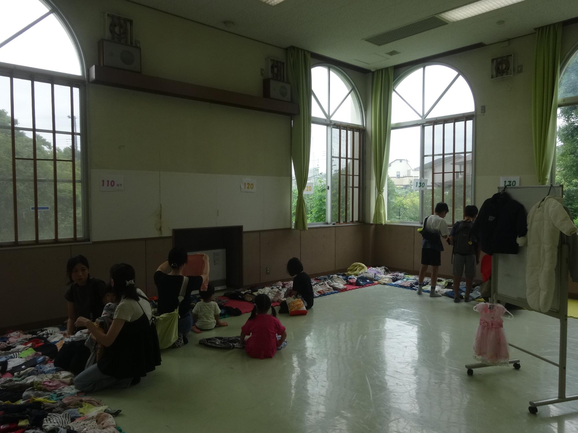 衣類を選ぶ親子や子どもたち