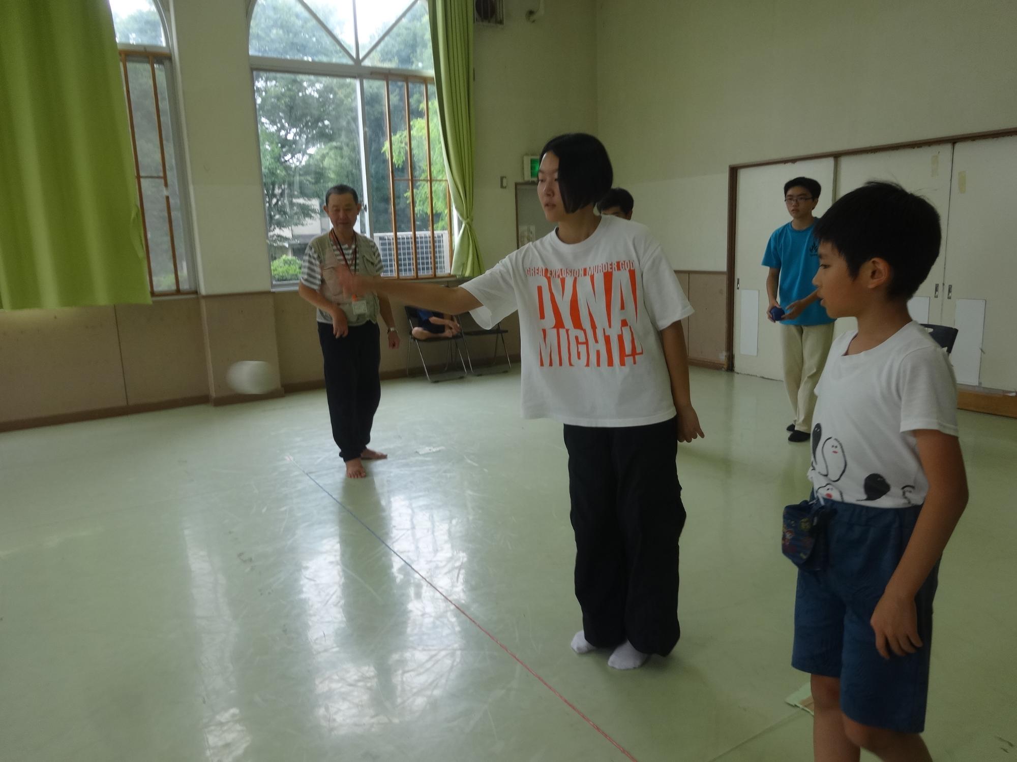 ジャックボールを投げる中学生とそれを見る小学生