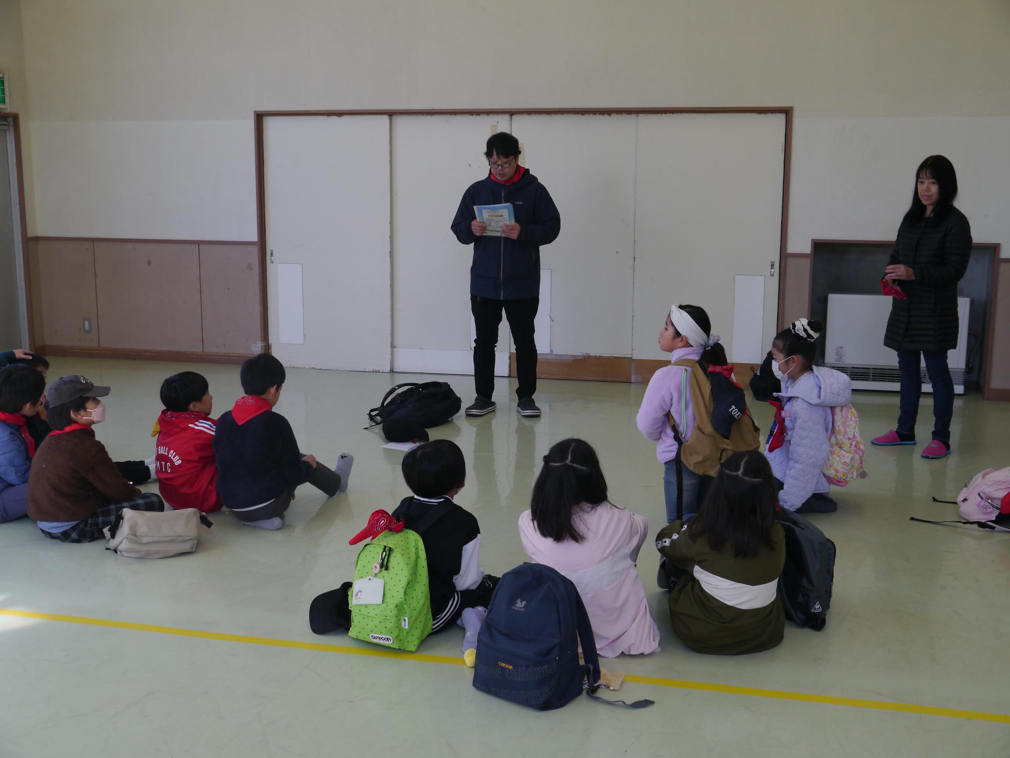 出発前に集合し、館長のお話を聞く子どもたちの写真