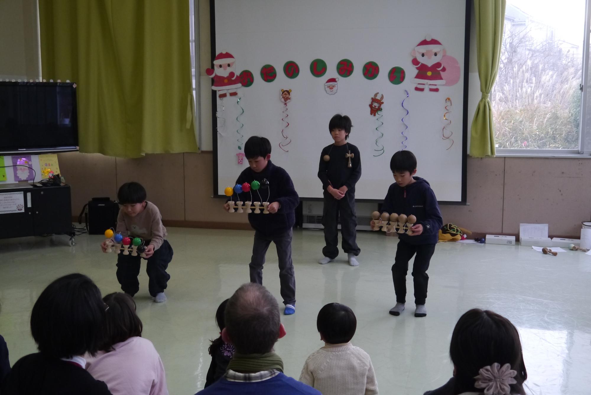 けん玉パフォーマンスで5連けん玉に挑戦する3人の小学生