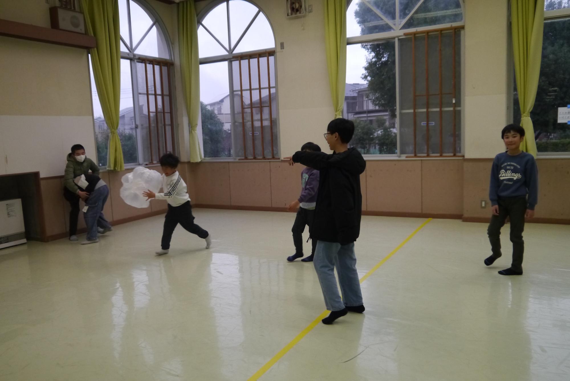 ゴミ袋風船をキャッチする子どもと笑いながら見ている子どもたち