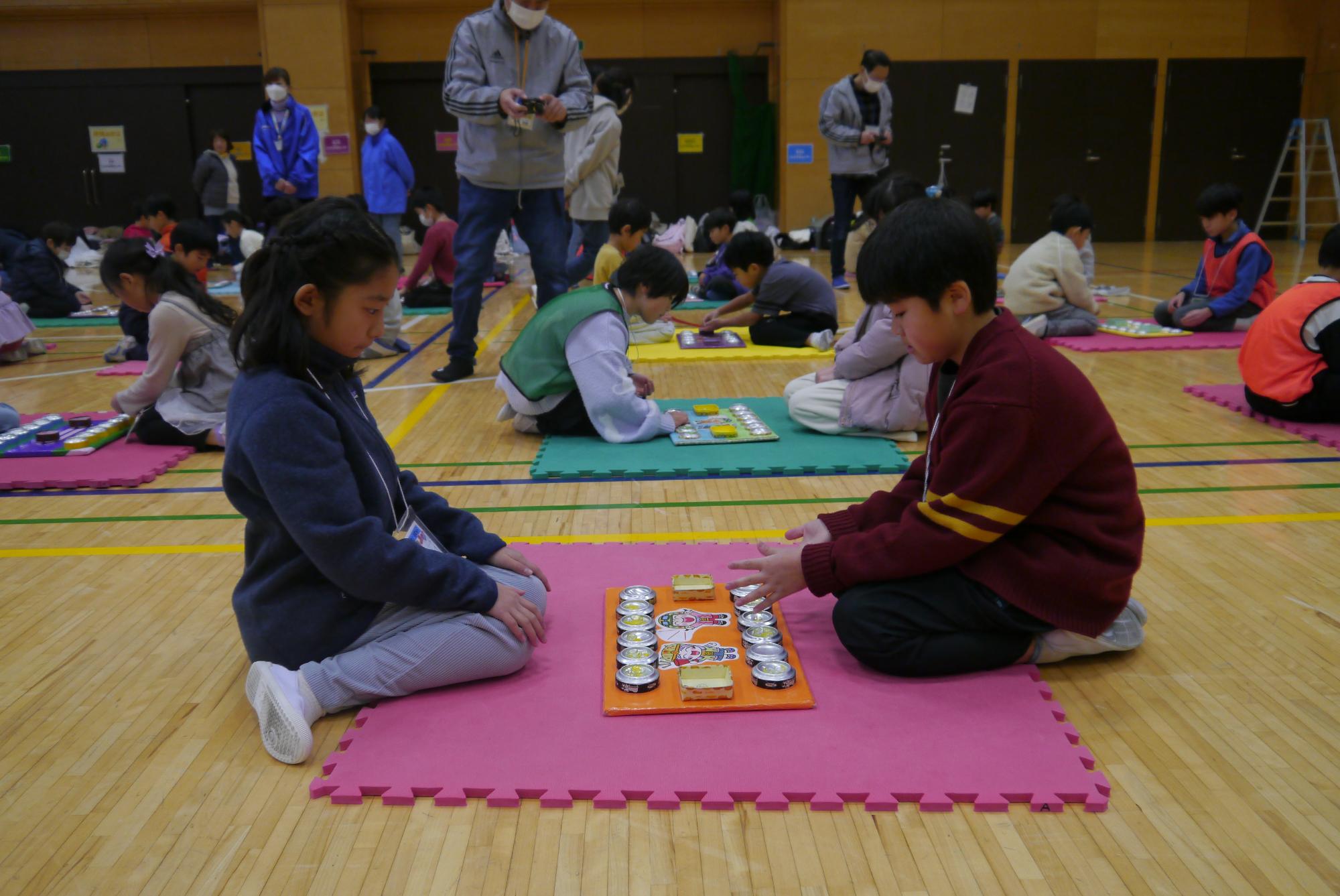 マンカラの試合をする小学生たち