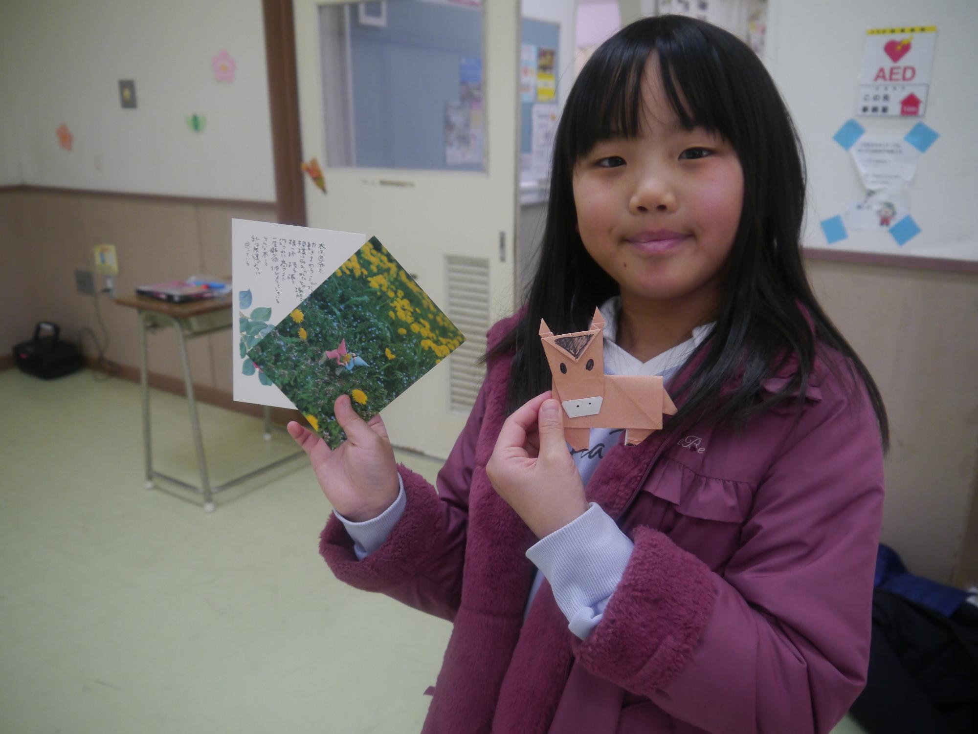 折り紙体験コーナーで馬を作った小学生の写真