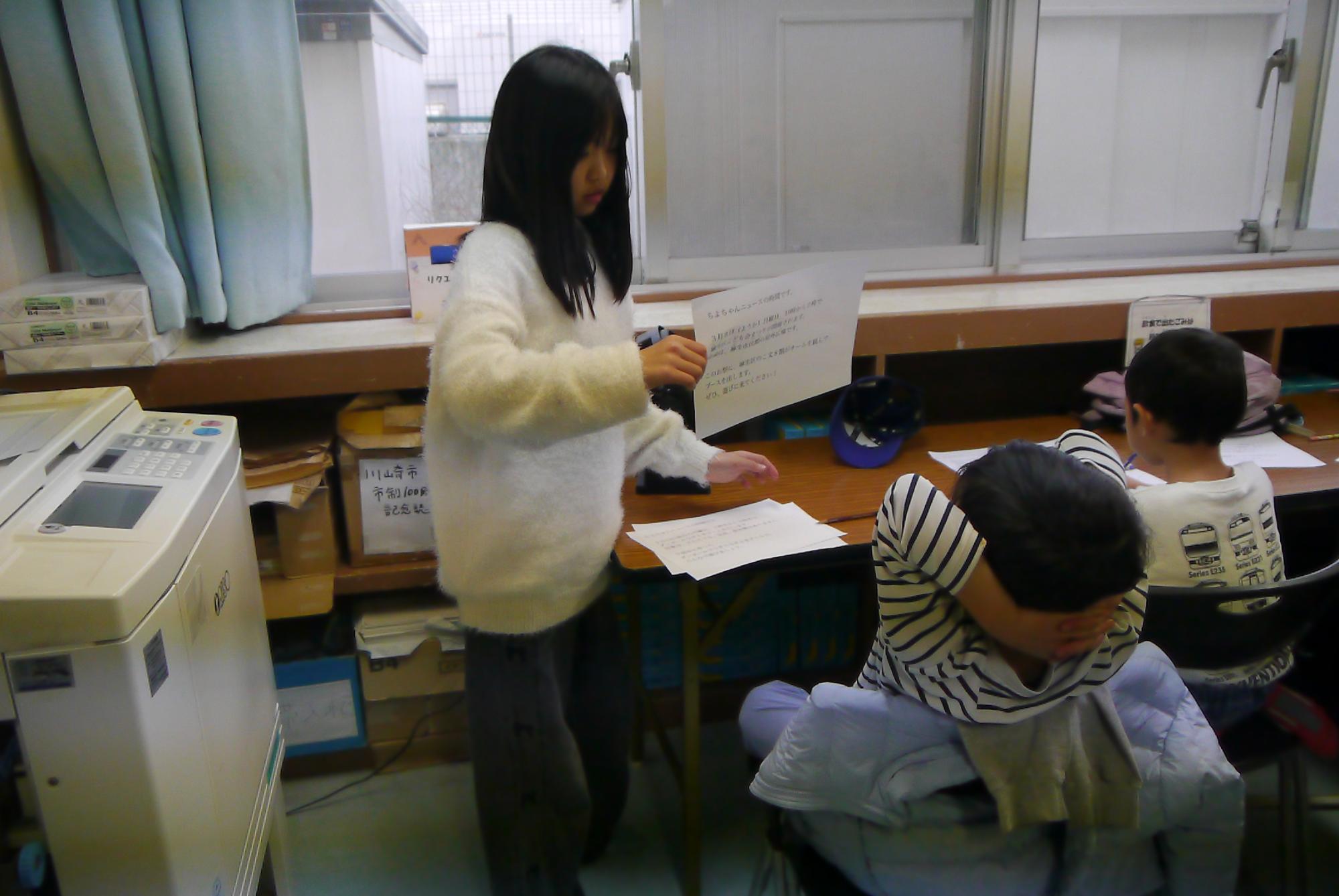 撮影前に台本の確認をする小5と小1の子どもの写真