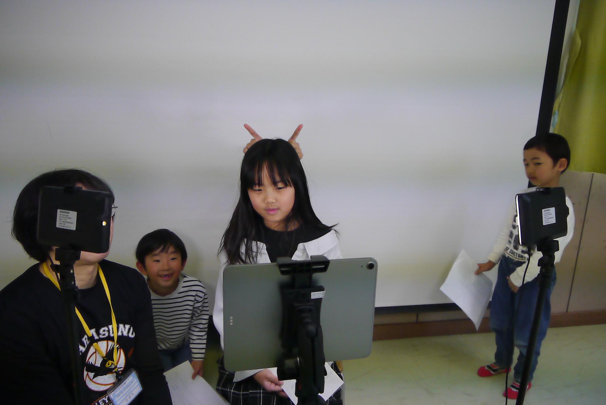 撮影の練習中にふざけ合う小学生の写真