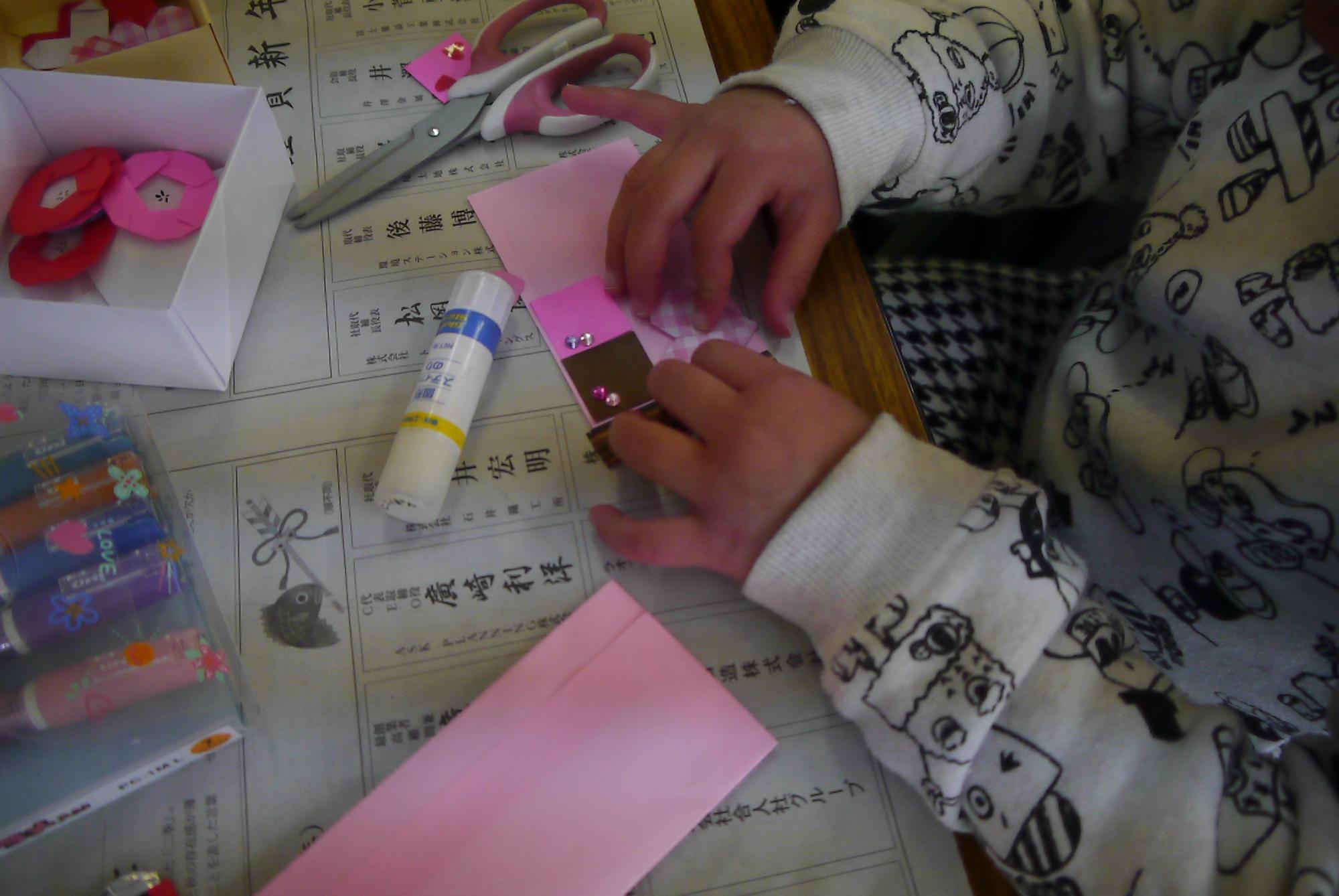 チョコレートの形をしたメッセージカードを作る幼児の手元