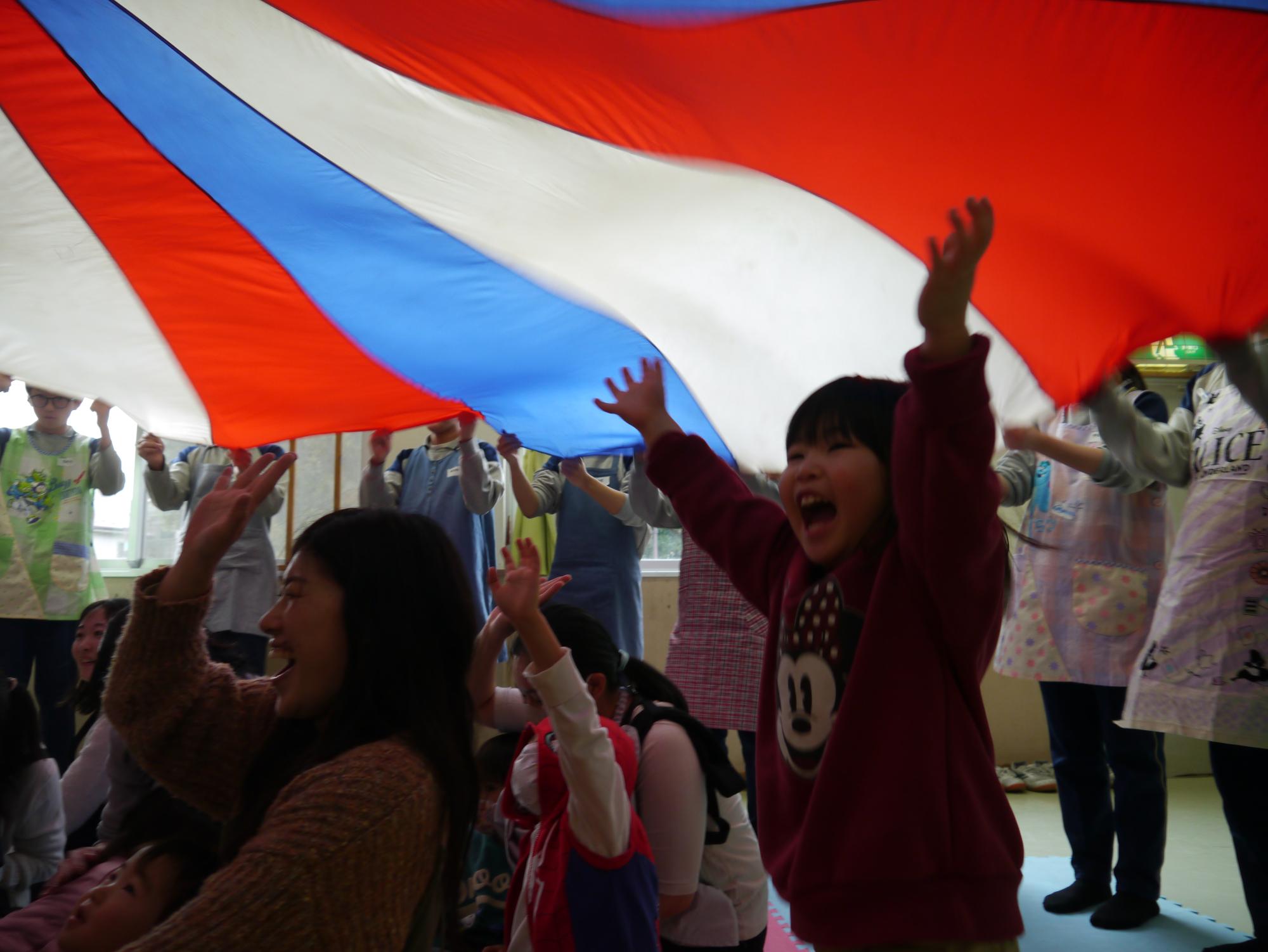 パラバルーンで遊ぶ幼児親子