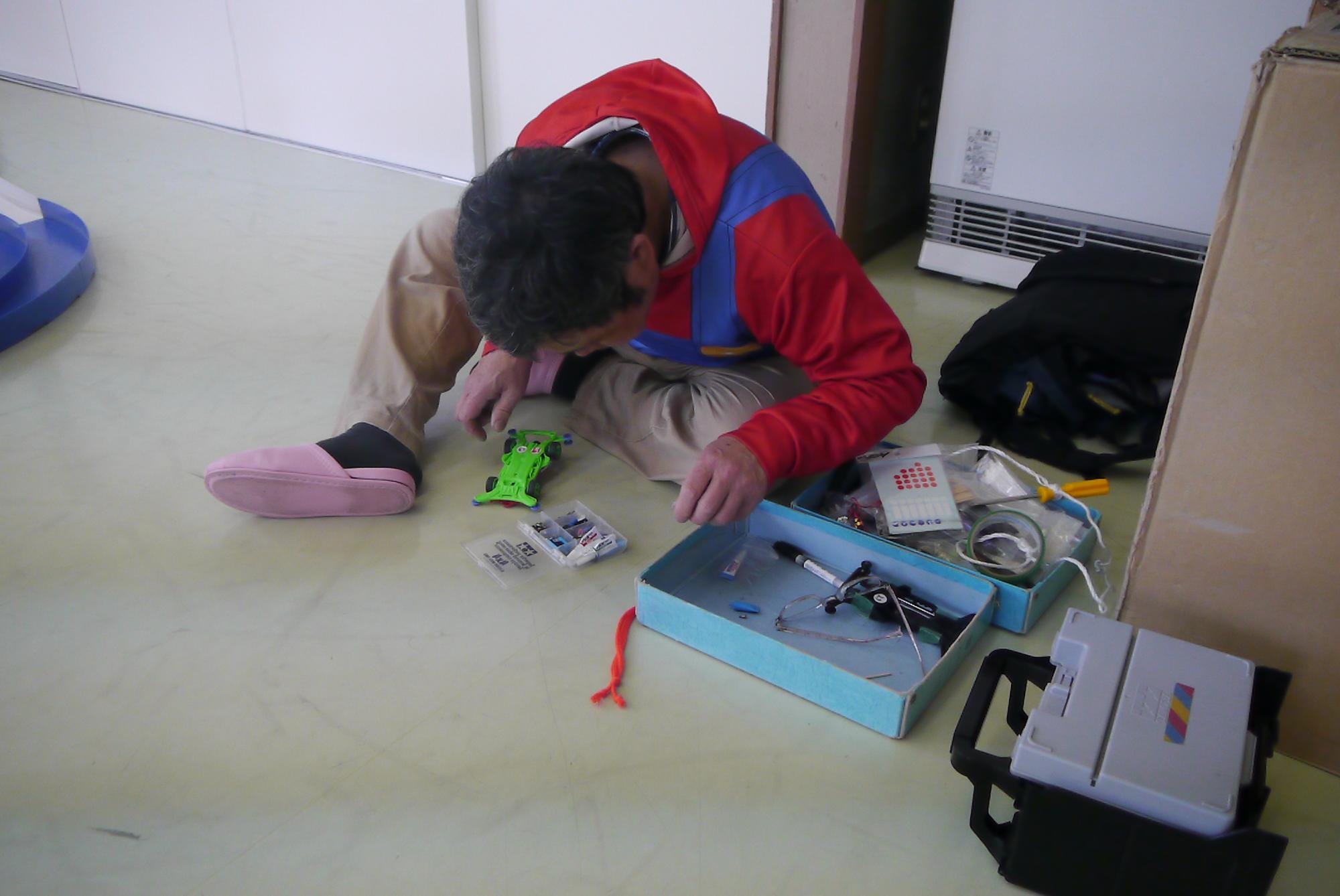 壊れた部品を修理する講師の先生