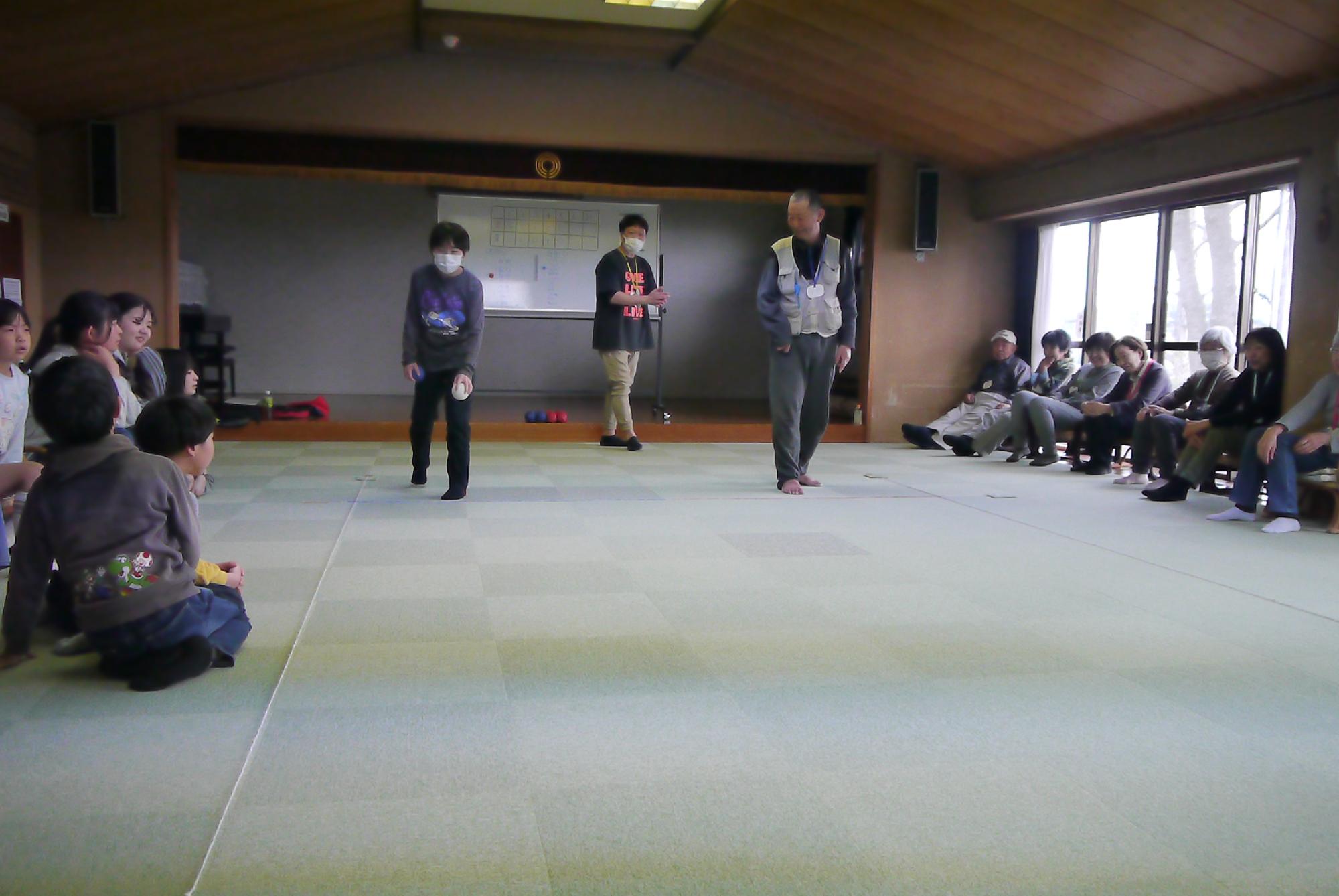 いこいの家のボッチャサークルのメンバーと一緒にボッチャをする子どもたち