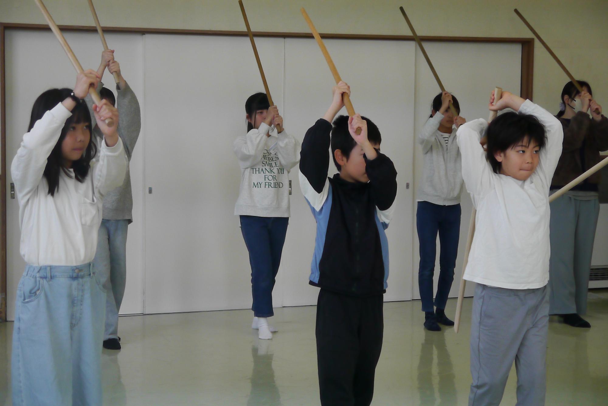 剣を振り上げる子どもたち