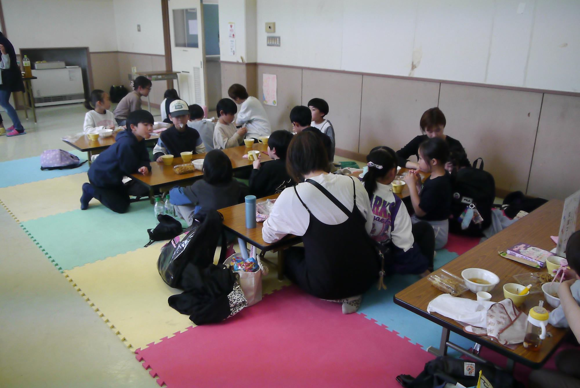 たくさんの参加者が座卓で食事をしている写真