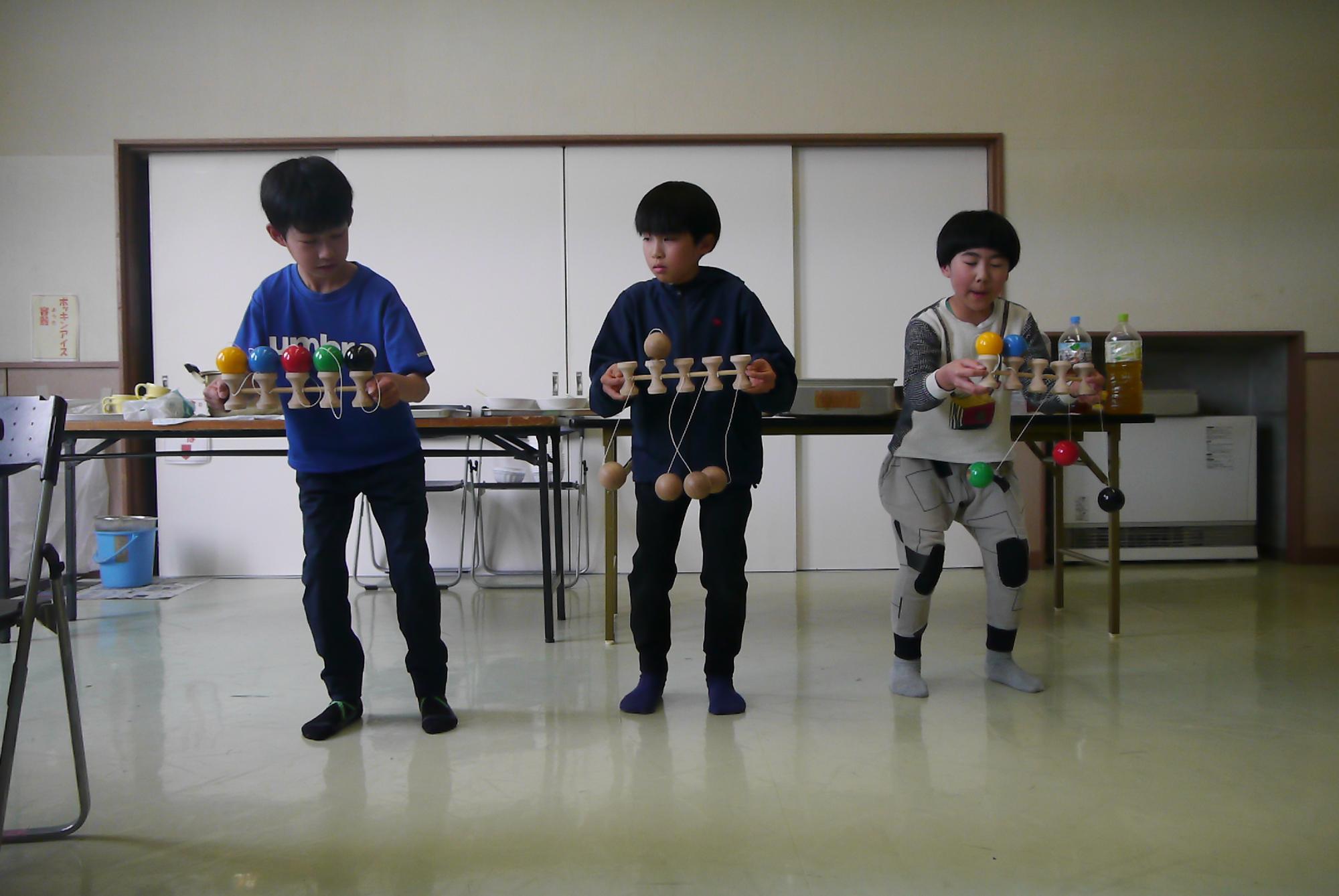 5連けん玉のパフォーマンスをしている小学生3人の写真