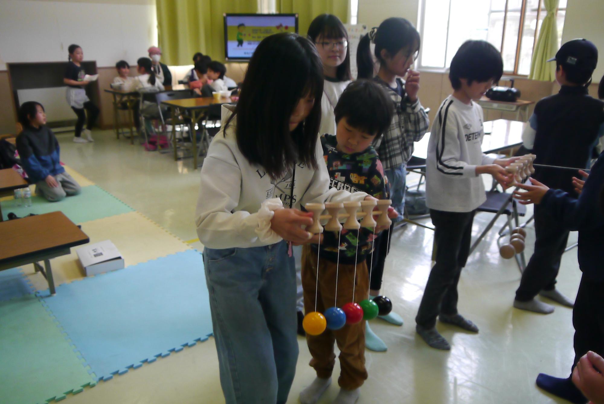 5連けん玉に初めて挑戦している小学生の写真