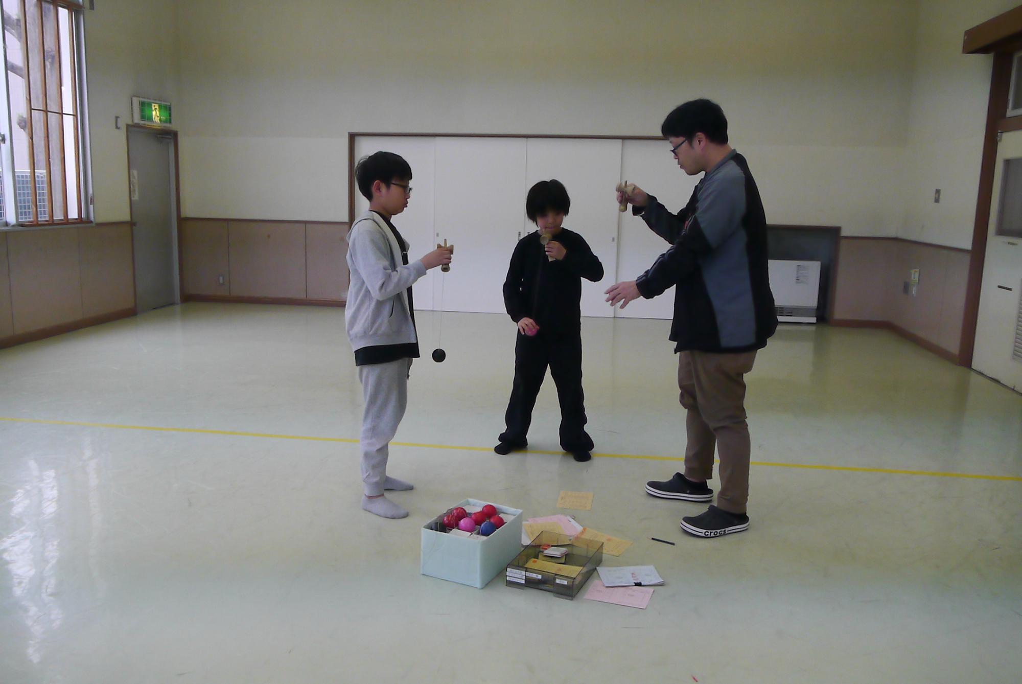 けん玉検定を受ける小学生と審査をする館長