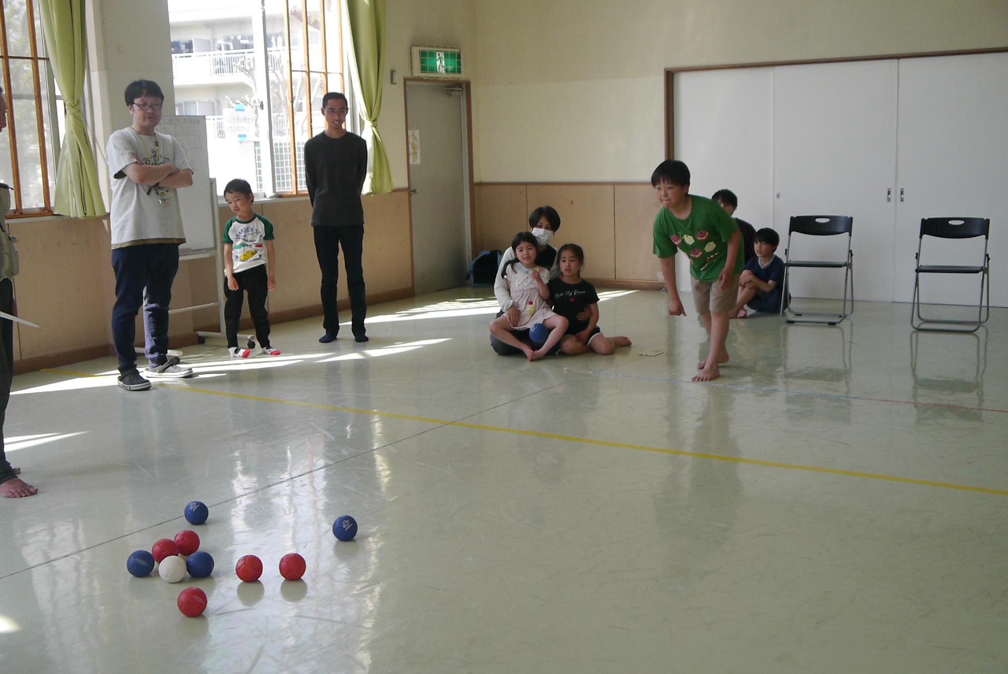 ボッチャをする高齢者と小学生