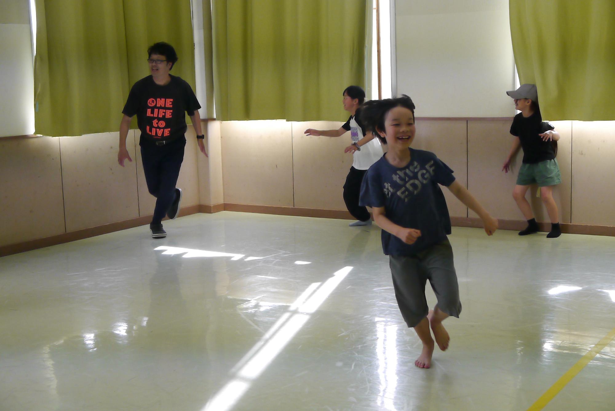 しっぽ取りゲームをして走っている小学生