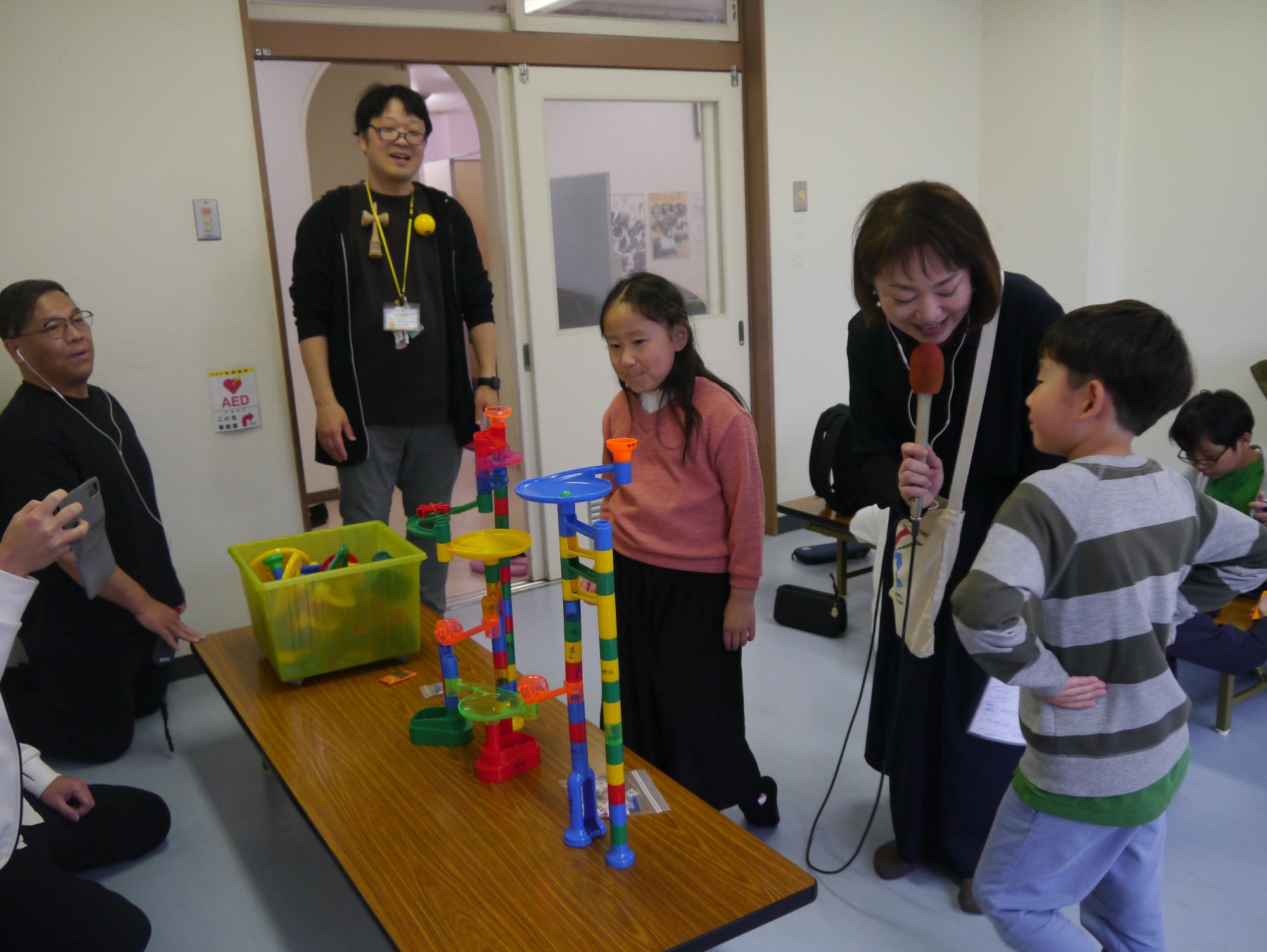 くみくみスロープで遊んでいる子どもたちがレポーターからインタビューを受けている