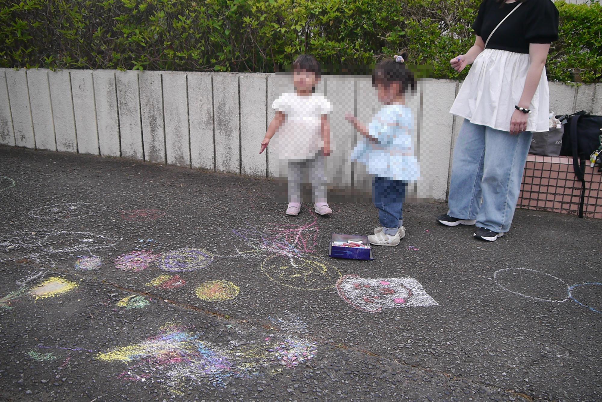 チョークで絵を描いたあとの幼児
