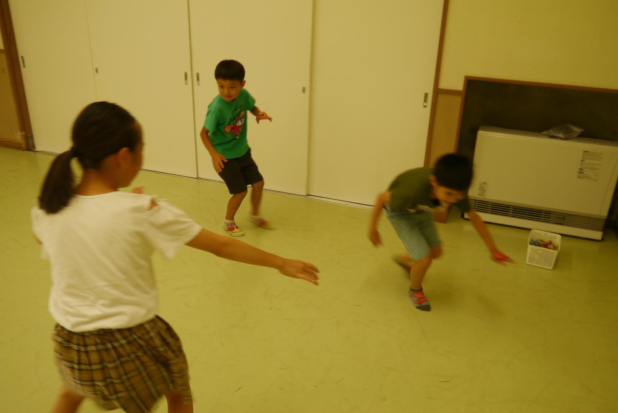 相手の人形を落とそうとする小学生と、逃げようとして人走る小学生の写真
