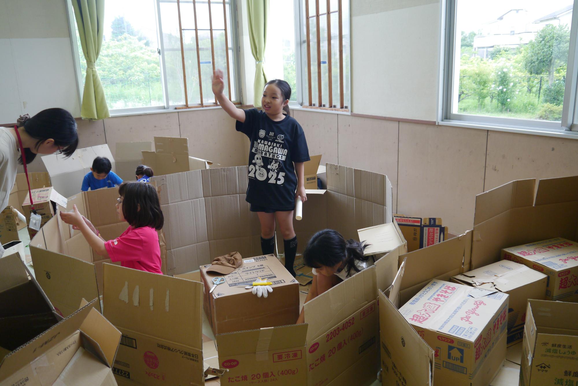 ダンボールを使って家を作る子どもたち