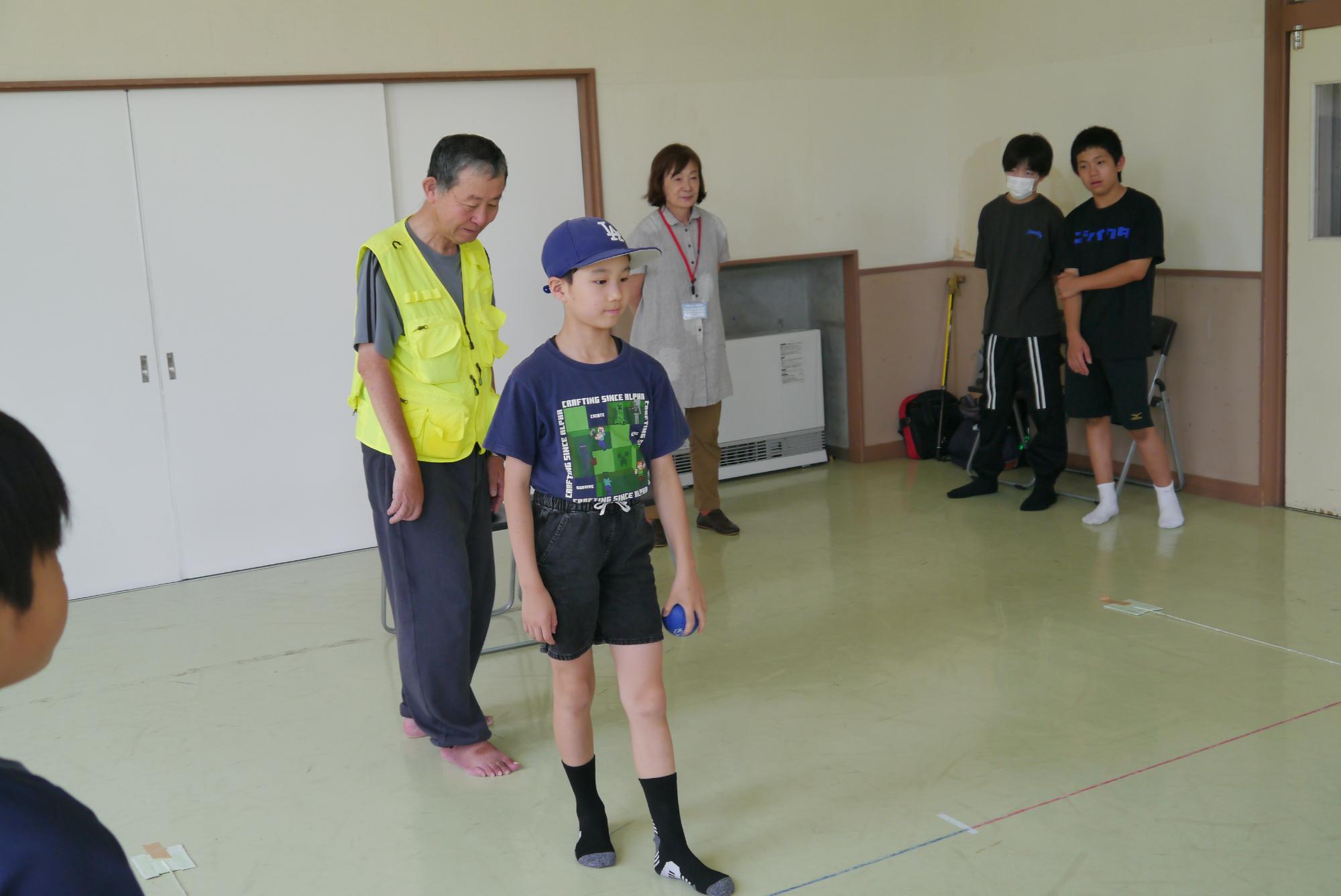 作戦を考えながら玉を投げる小学生