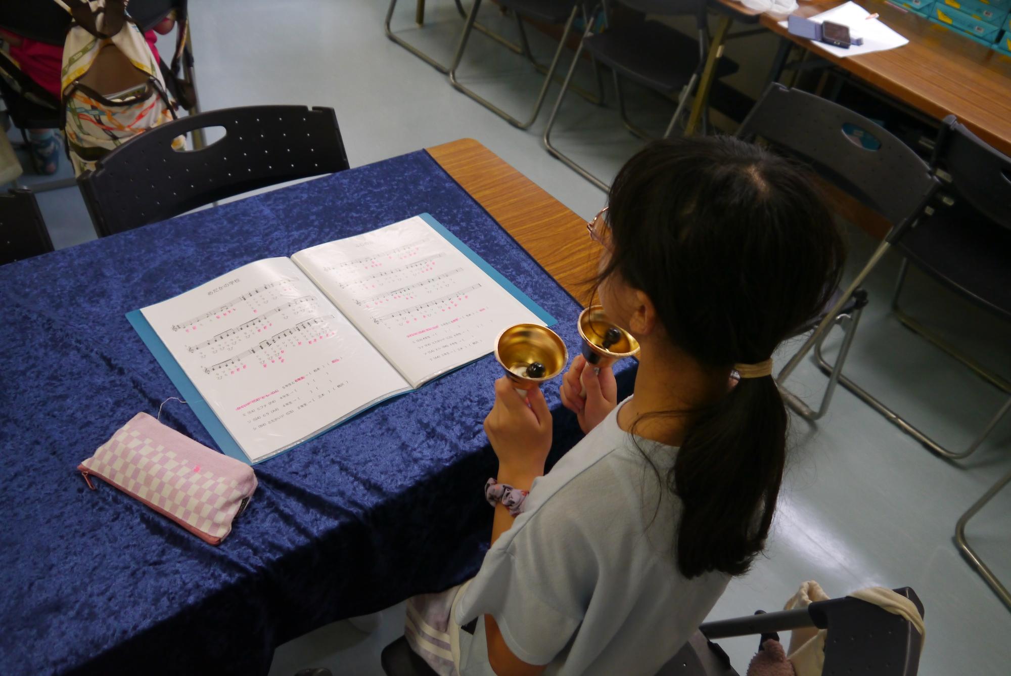 ハンドベルを構えている小学生