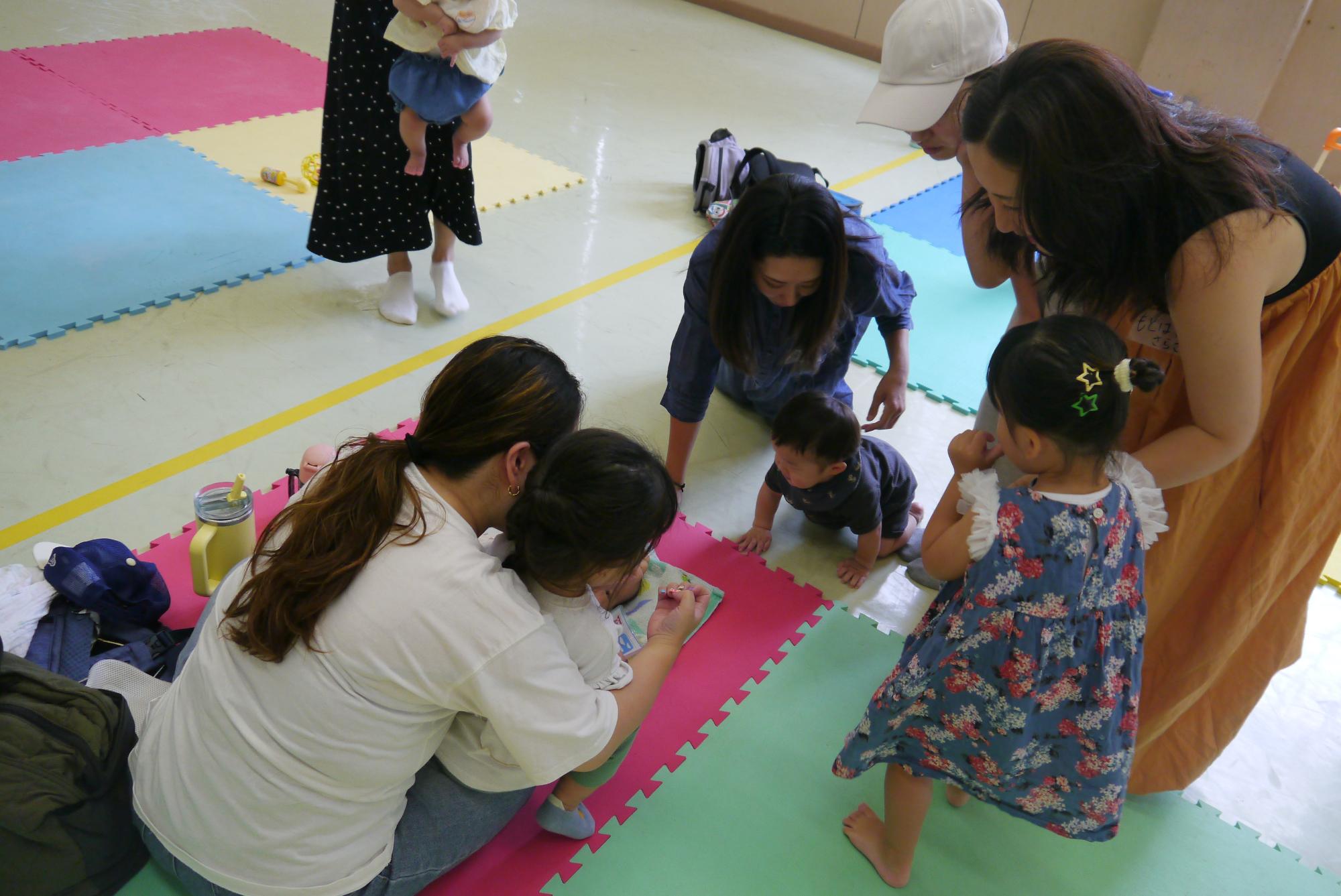 可愛いネイルアートをしている保護者の爪を見ているお母さんたち