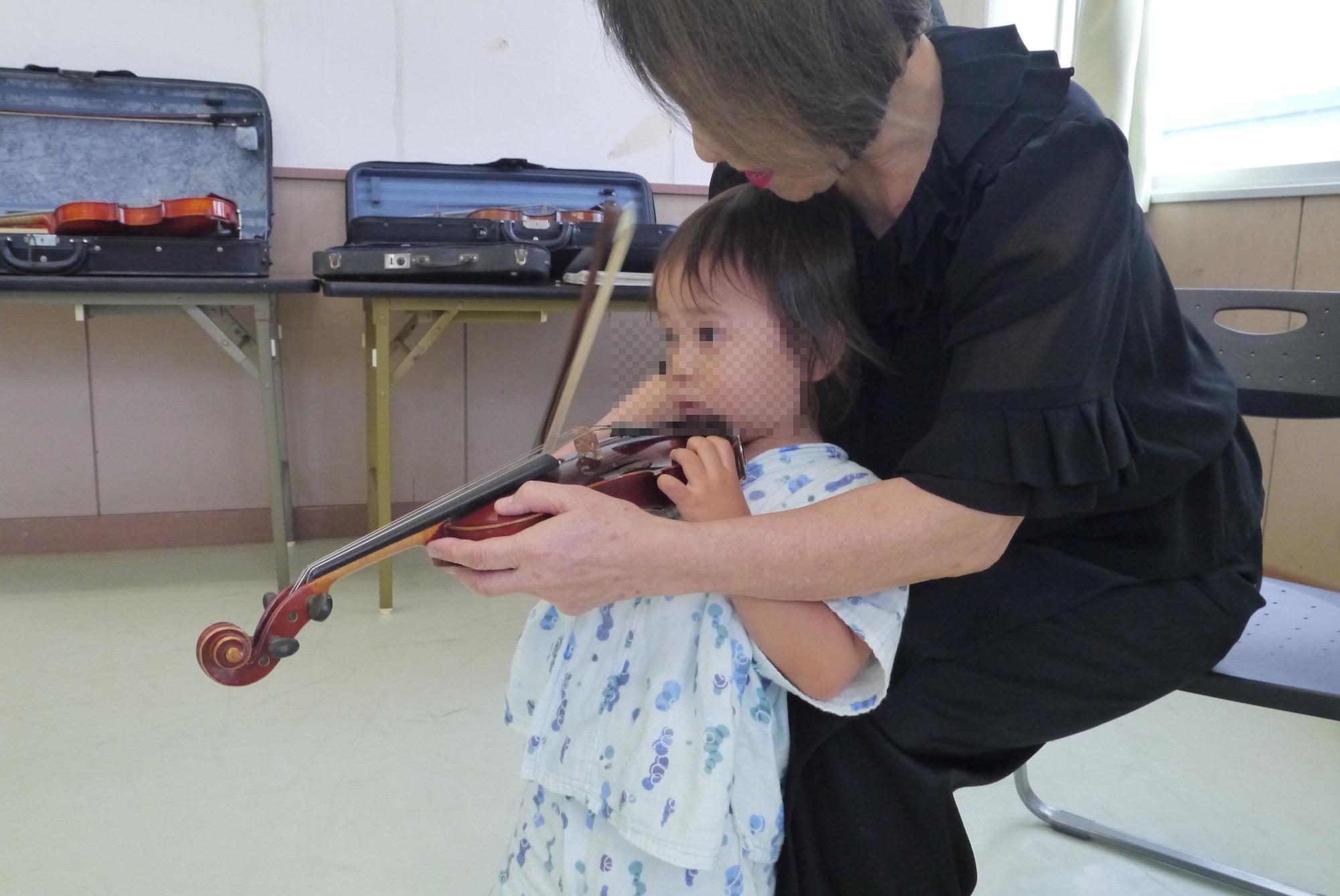バイオリンの体験をする幼児