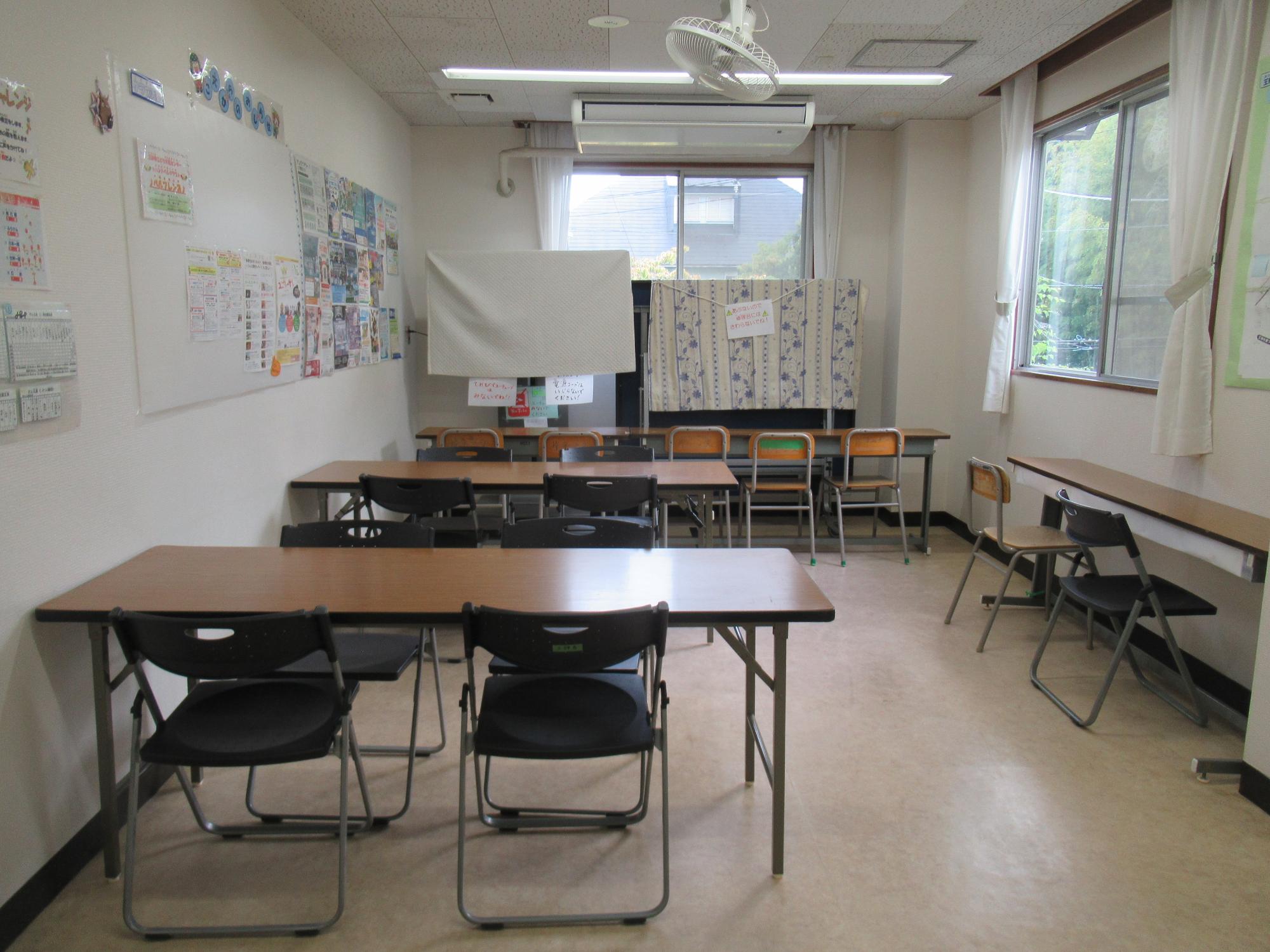 窓があり、長机に椅子が設置された学習室の写真