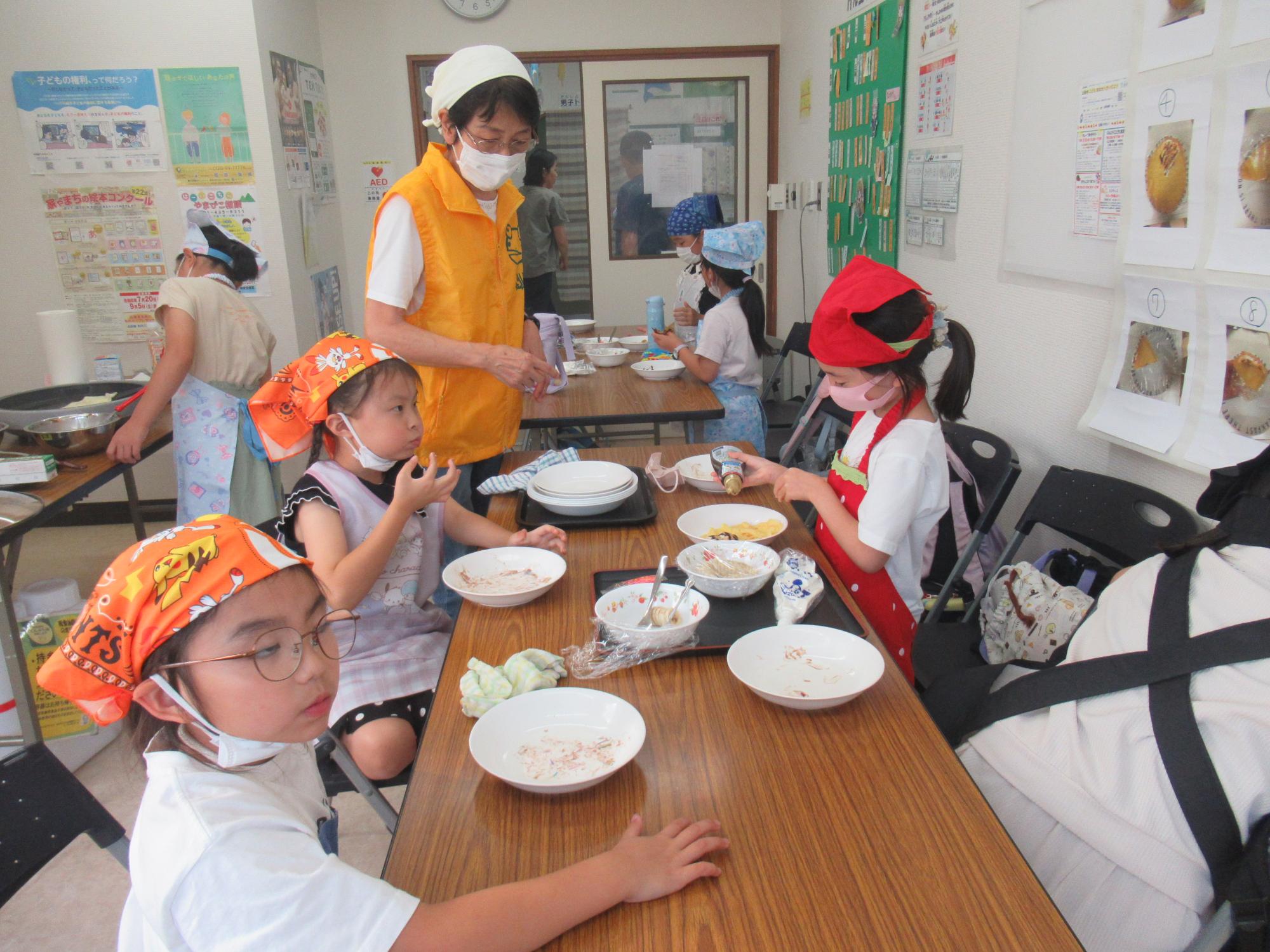 焼いたクレープにチョコシロップをかけて食べている子ども達の様子