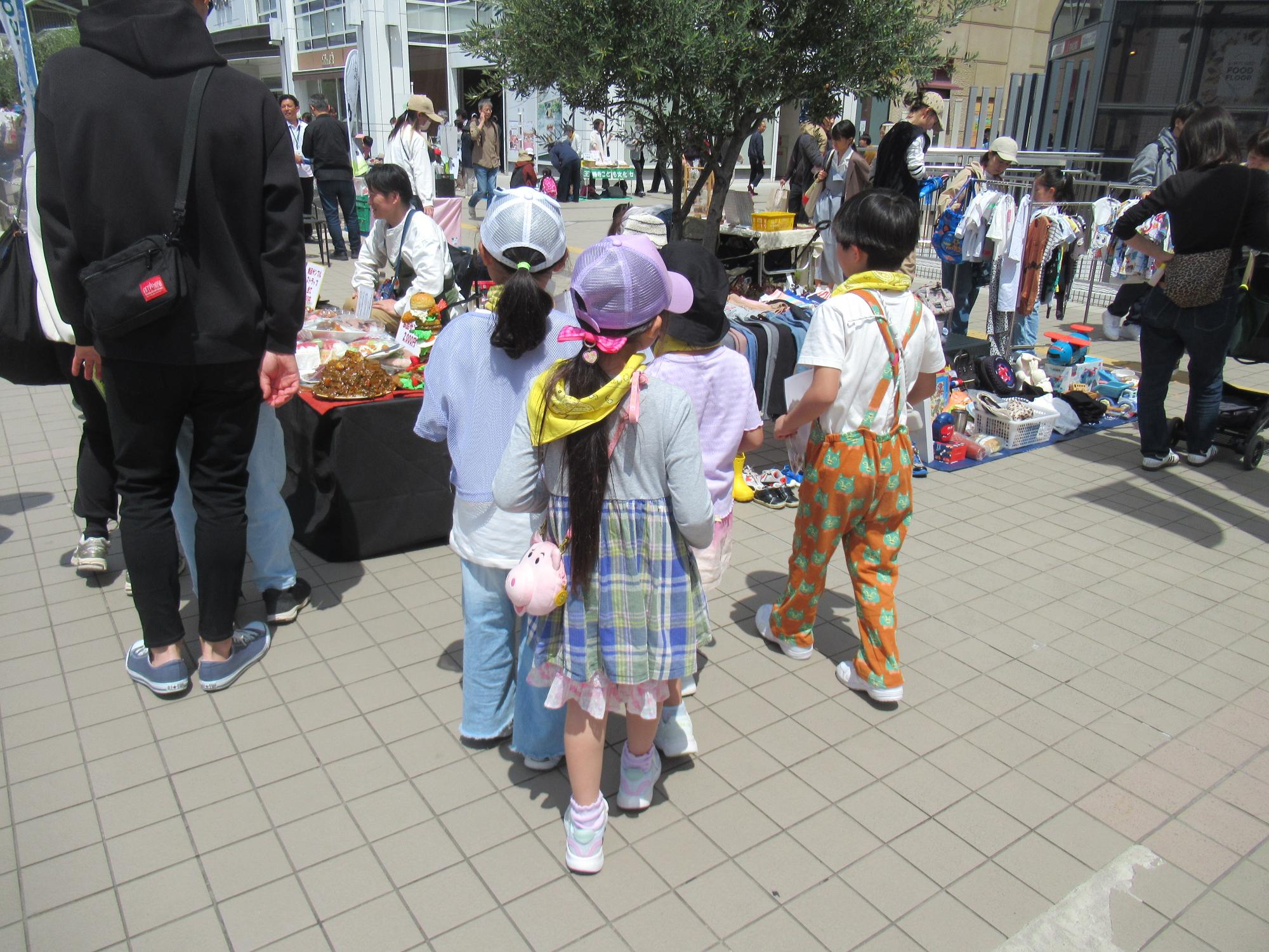 フリーマーケットで販売の宣伝にまわる子ども達の写真